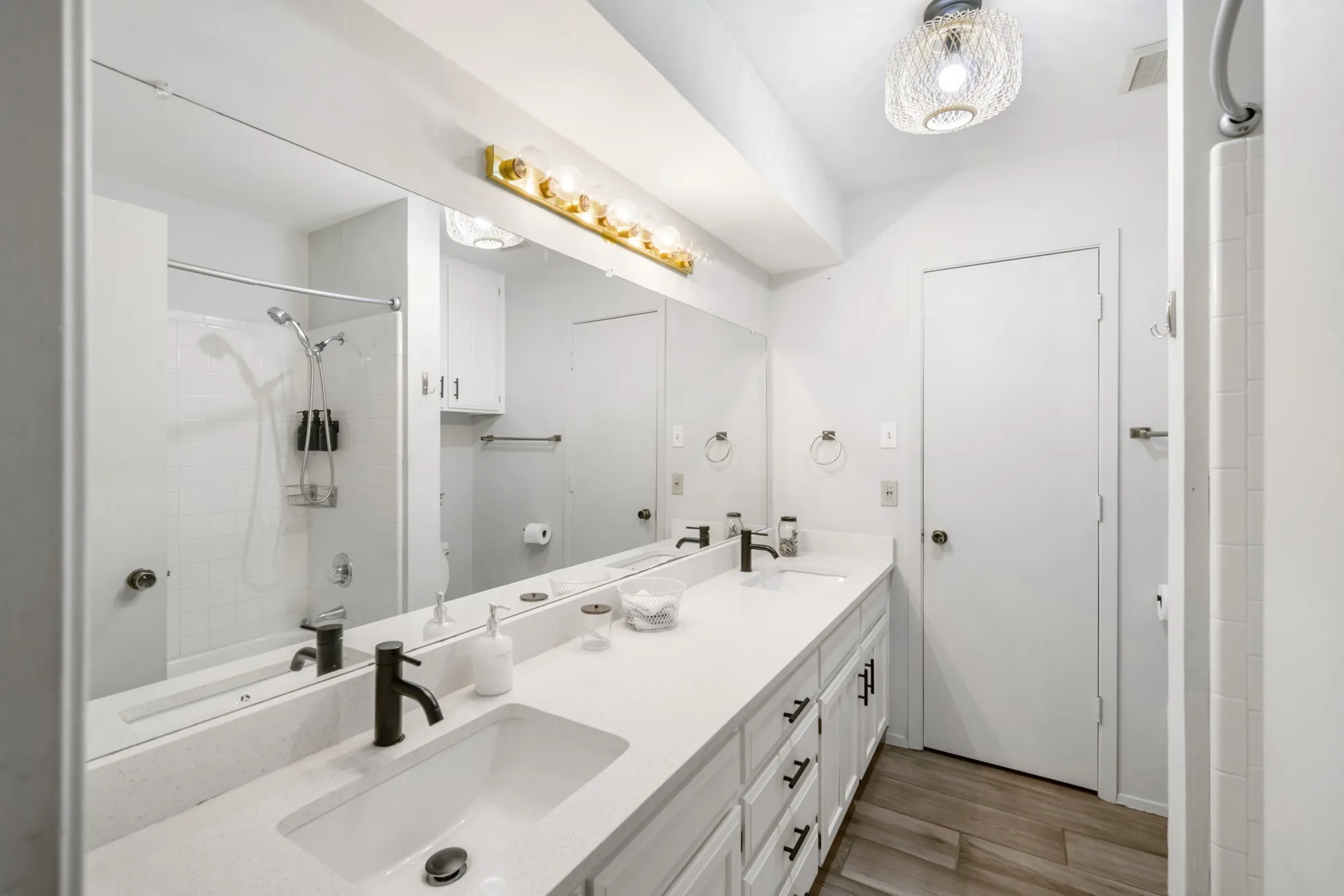 Primary bathroom features built in storage with dual sinks and a walk in closet