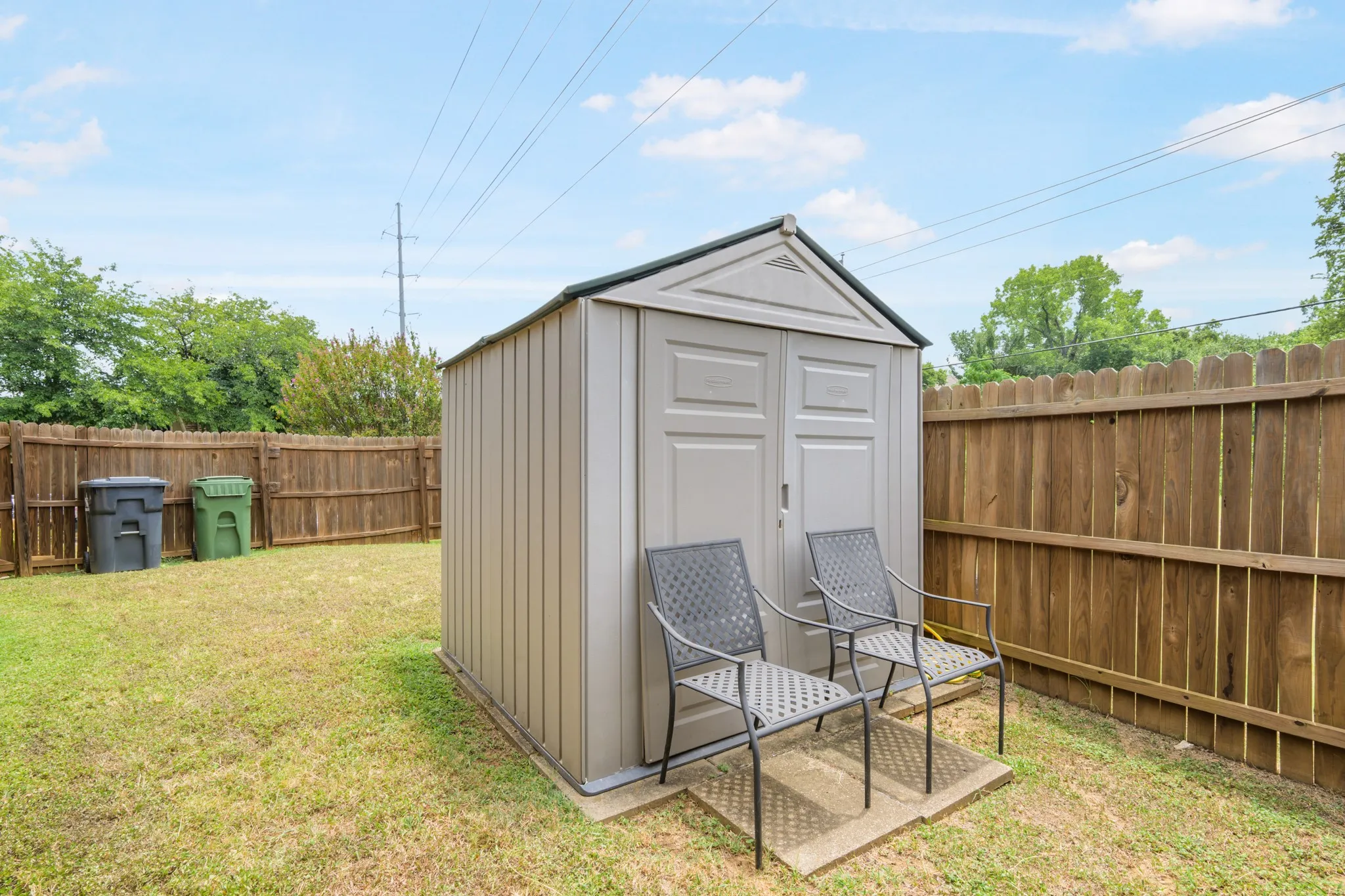 The fully fenced yard features a storage shed.