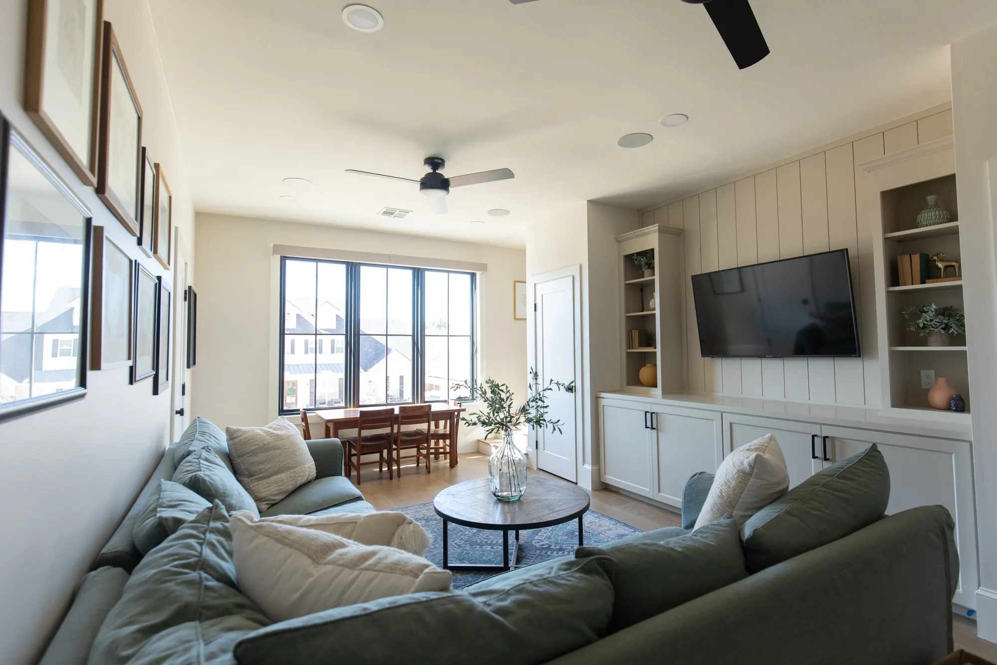 Upstairs Living room with ceiling fan, built in features, and light wood finished floors