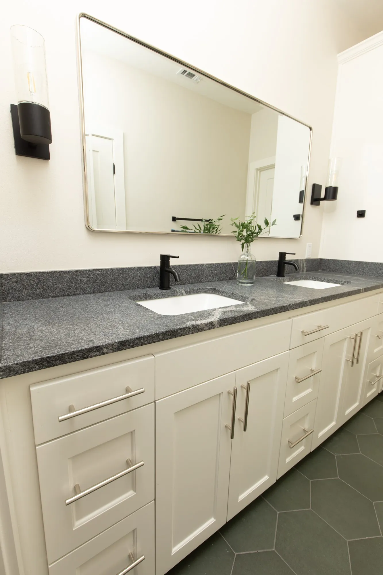 Bathroom with dark tile patterned flooring and double vanity