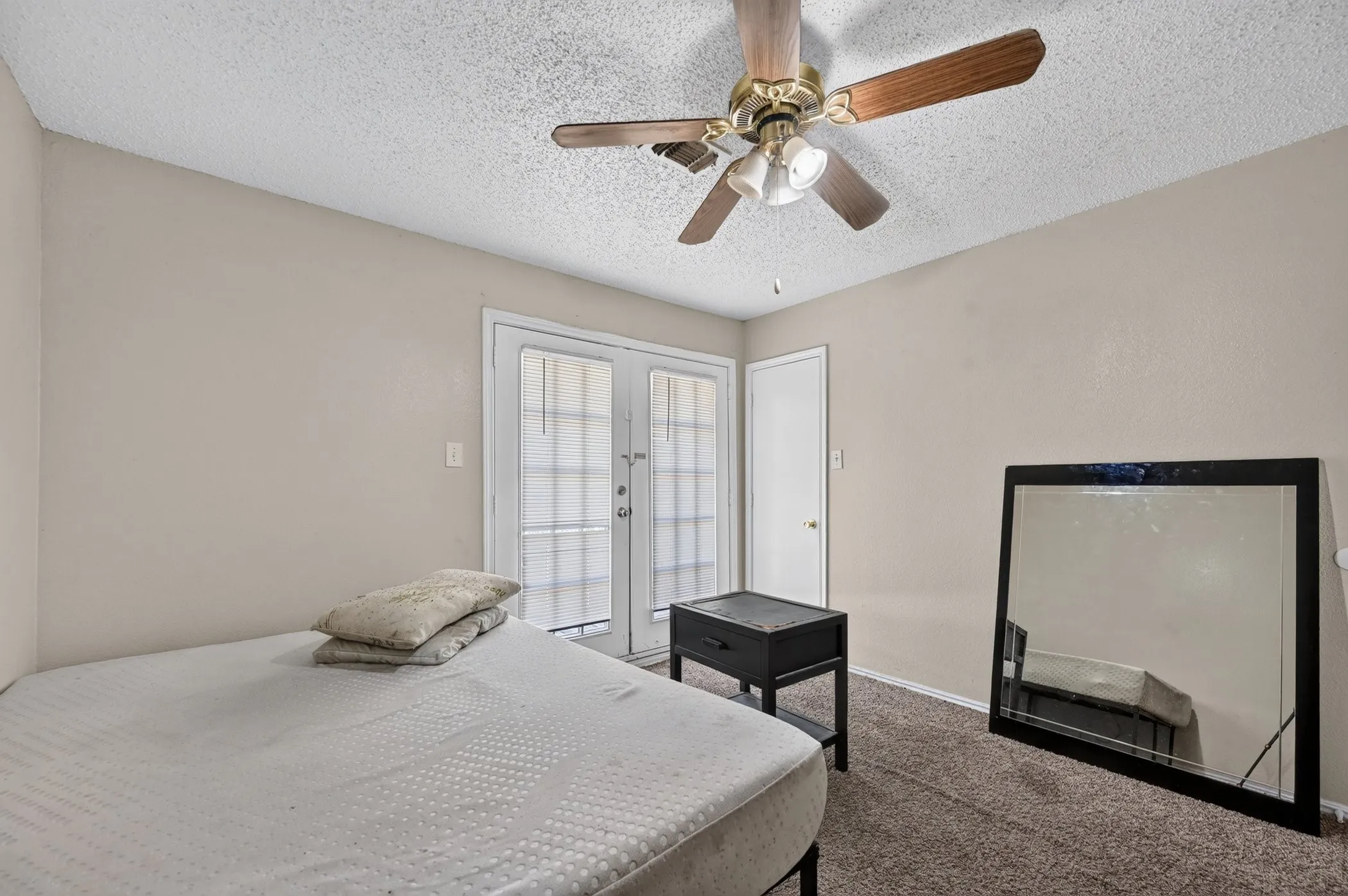 Ceiling fan with integrated lighting, double French doors, and neutral wall paint