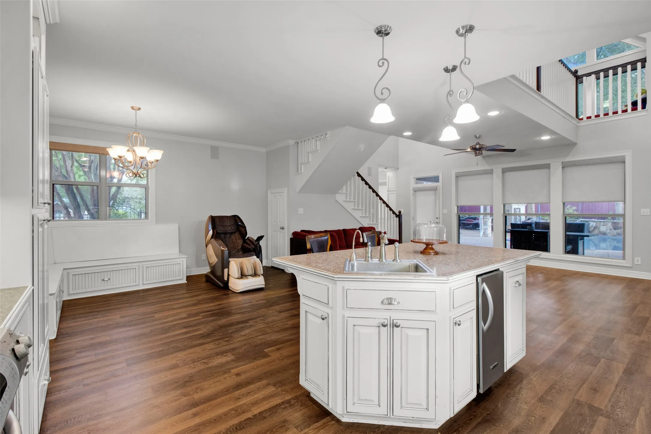 Open-concept living area featuring an angular kitchen island with an undermount sink and beverage cooler
