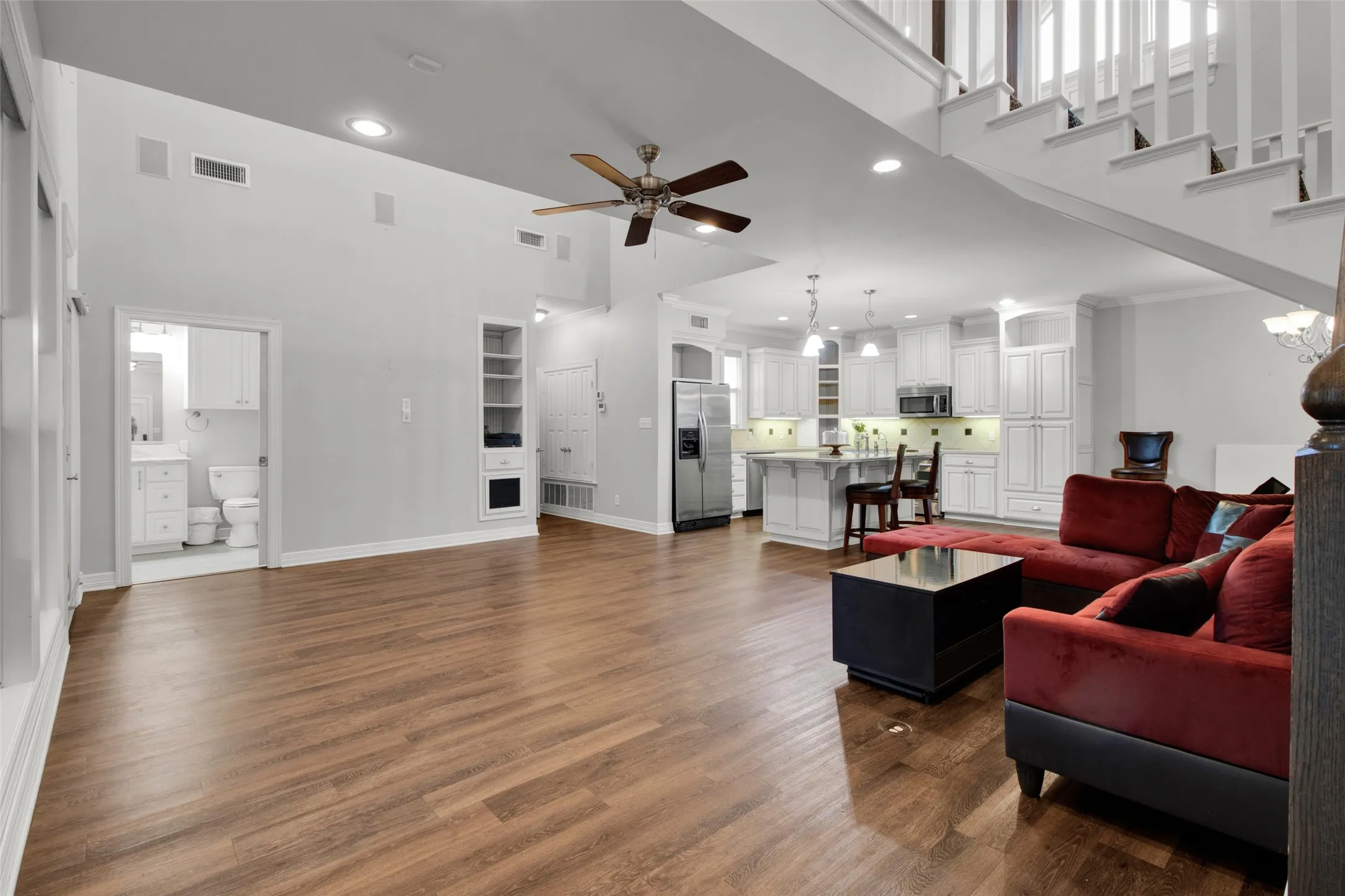 Open-concept living space featuring wood-finish flooring, recessed lighting, and a ceiling fan