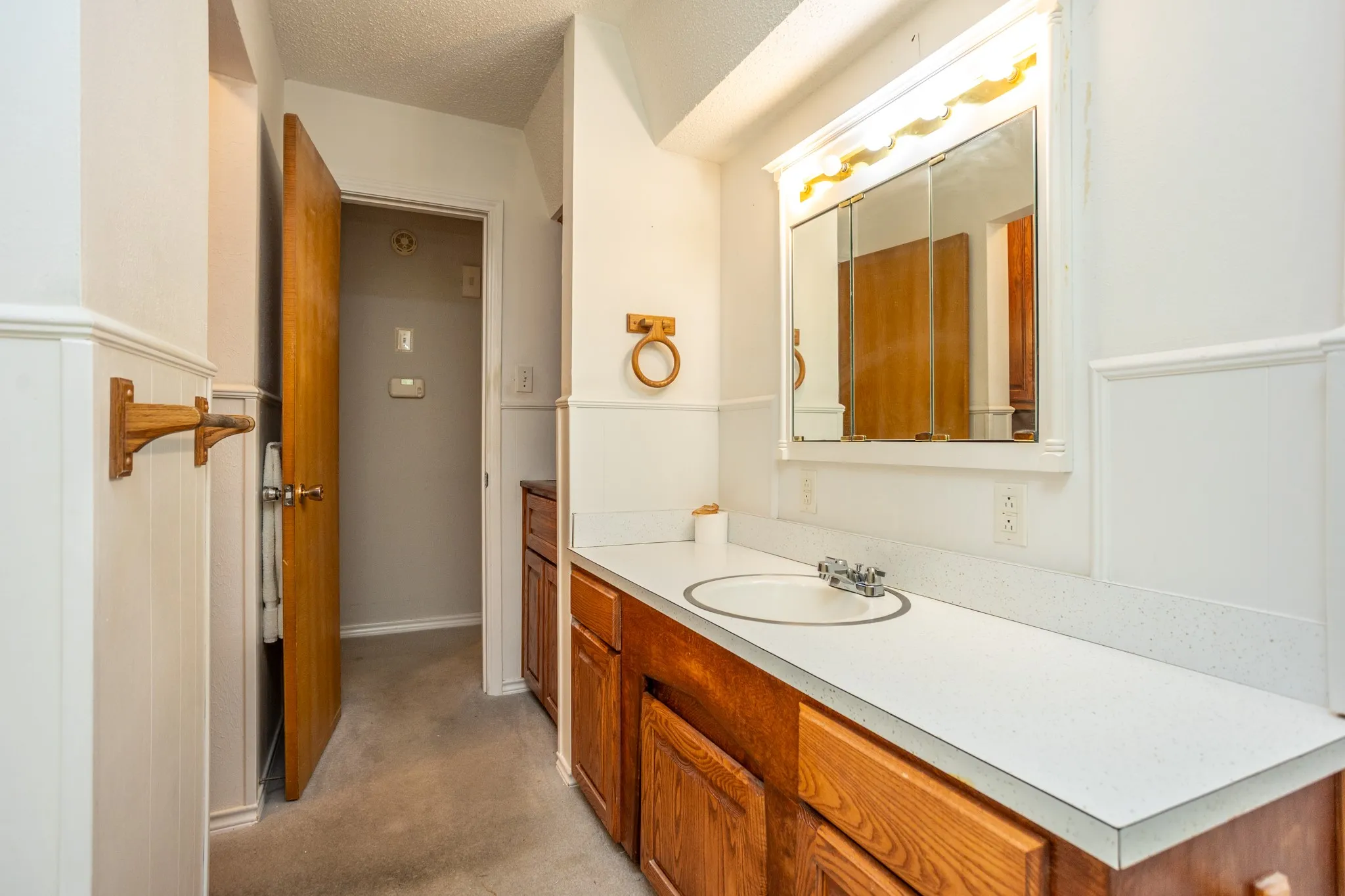 Hall bath has a tub shower combo and long vanity area.