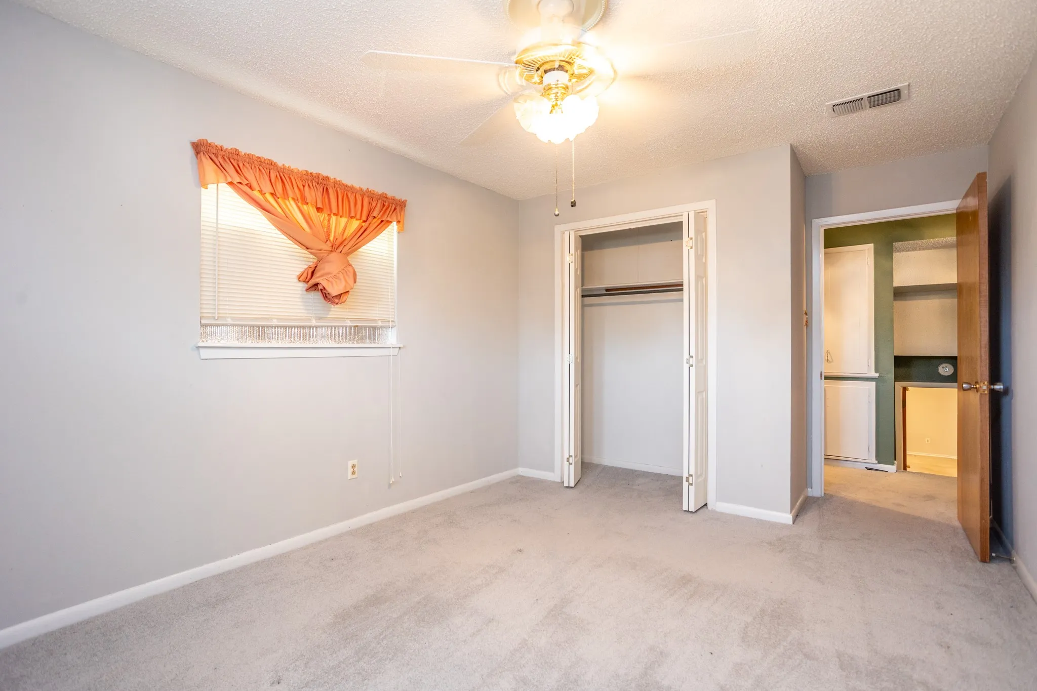 Second upstairs bedroom also has ceiling fan.  In hall is a storage cabinet..  Also shows stairs going down to living area.