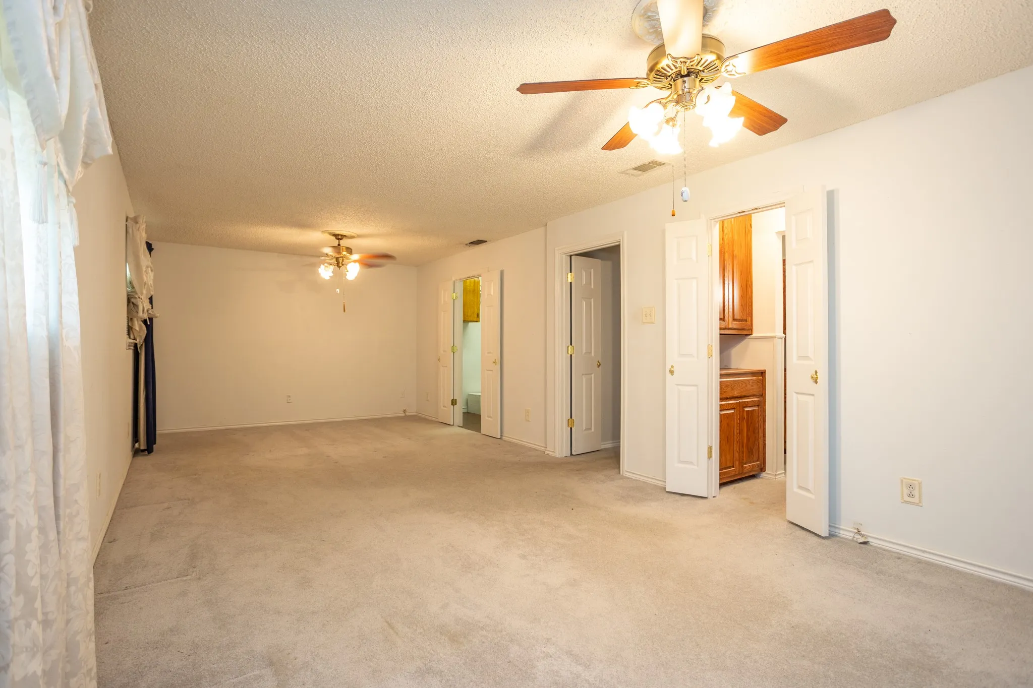 Oversized master has space for a sitting area as well as room for sleeping area.  Door opens to bathroom and lighted door is to the huge closet.  2 ceiling fans
