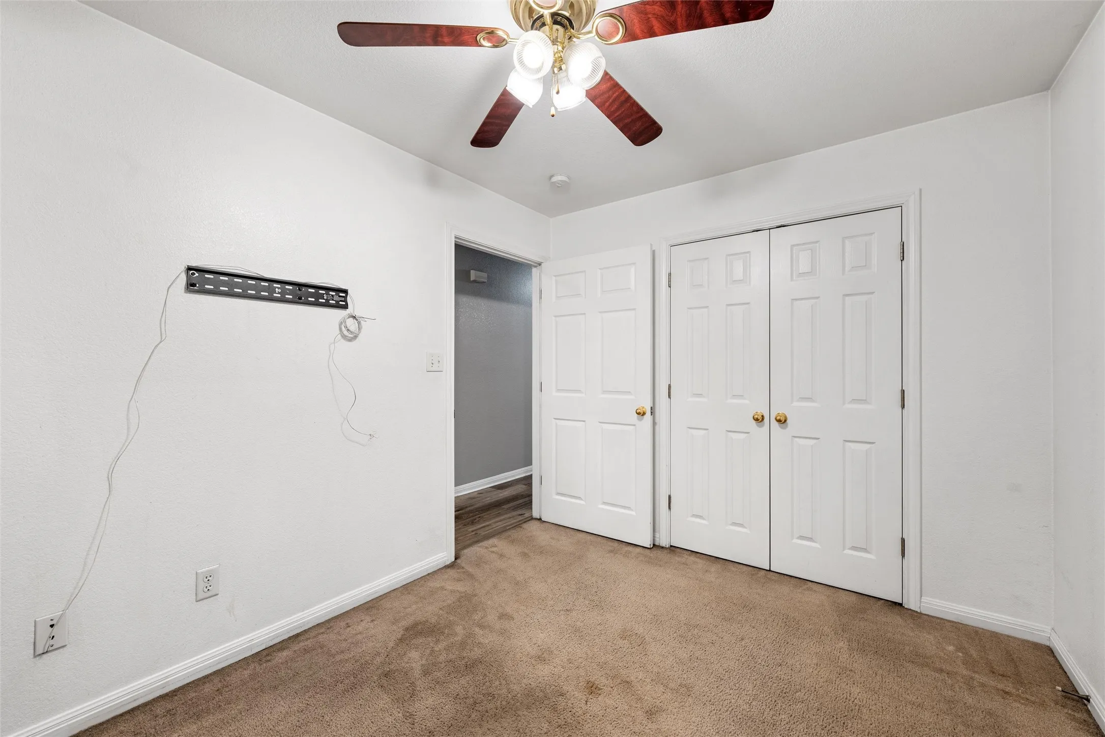 Unfurnished bedroom featuring carpet flooring, baseboards, a closet, and ceiling fan