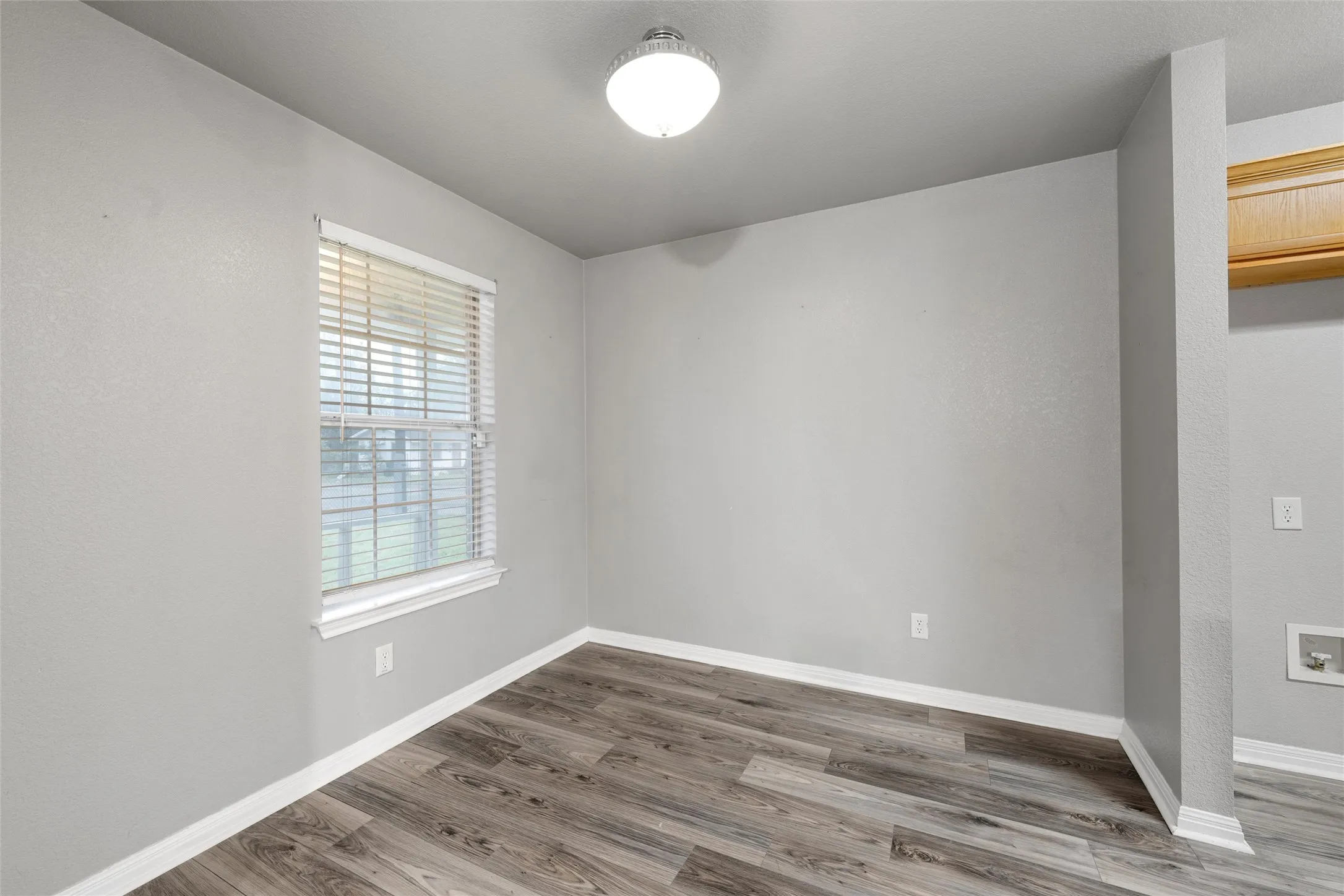 Spare room featuring wood finished floors and baseboards