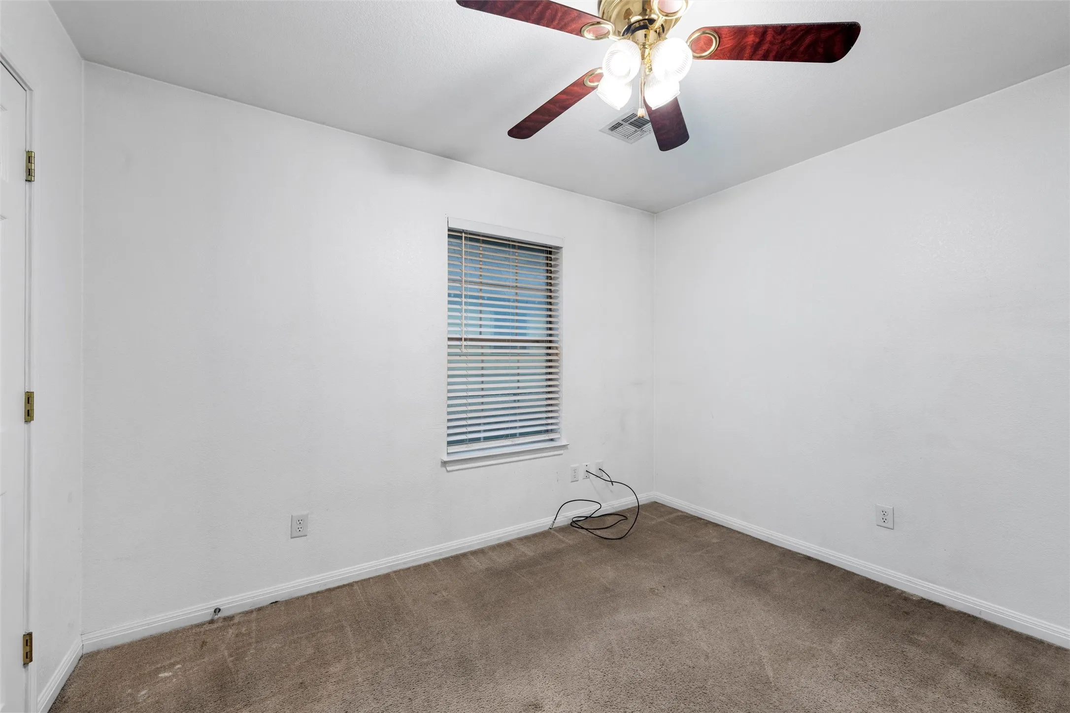 Unfurnished room with carpet floors, baseboards, and ceiling fan