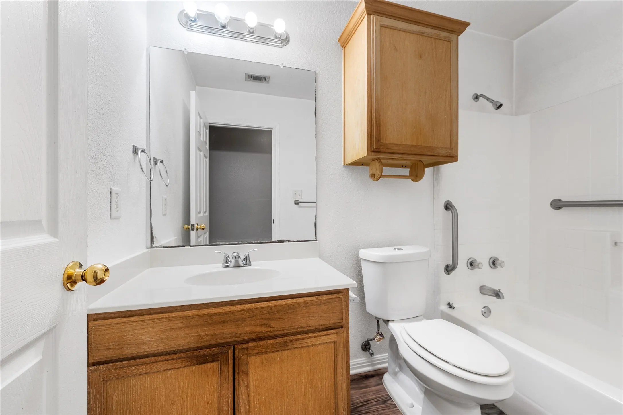 Bathroom with vanity, toilet, shower / bath combination, and wood finished floors