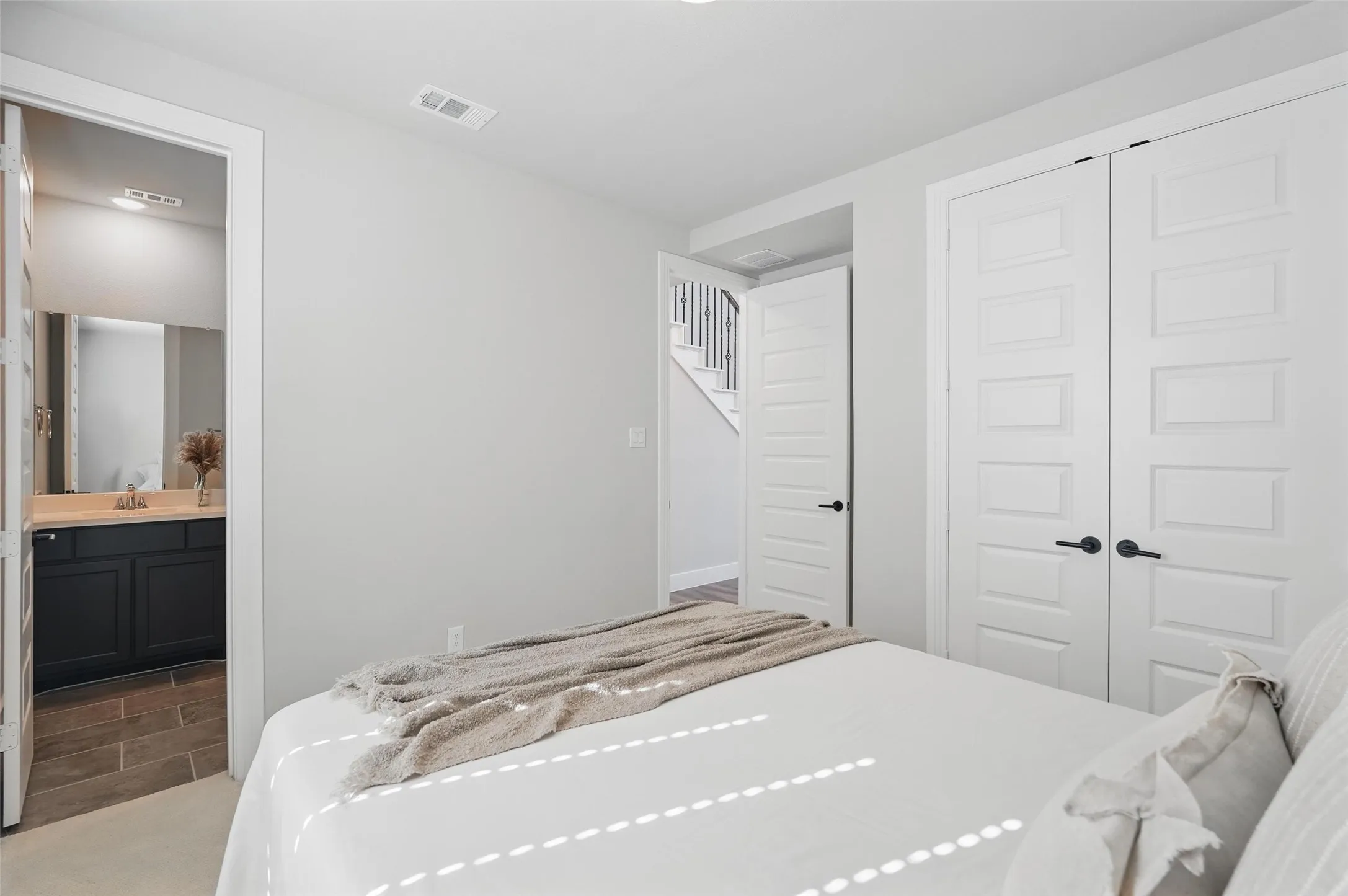 Recessed lighting, wood-finish flooring, white paneled doors, and matte black hardware