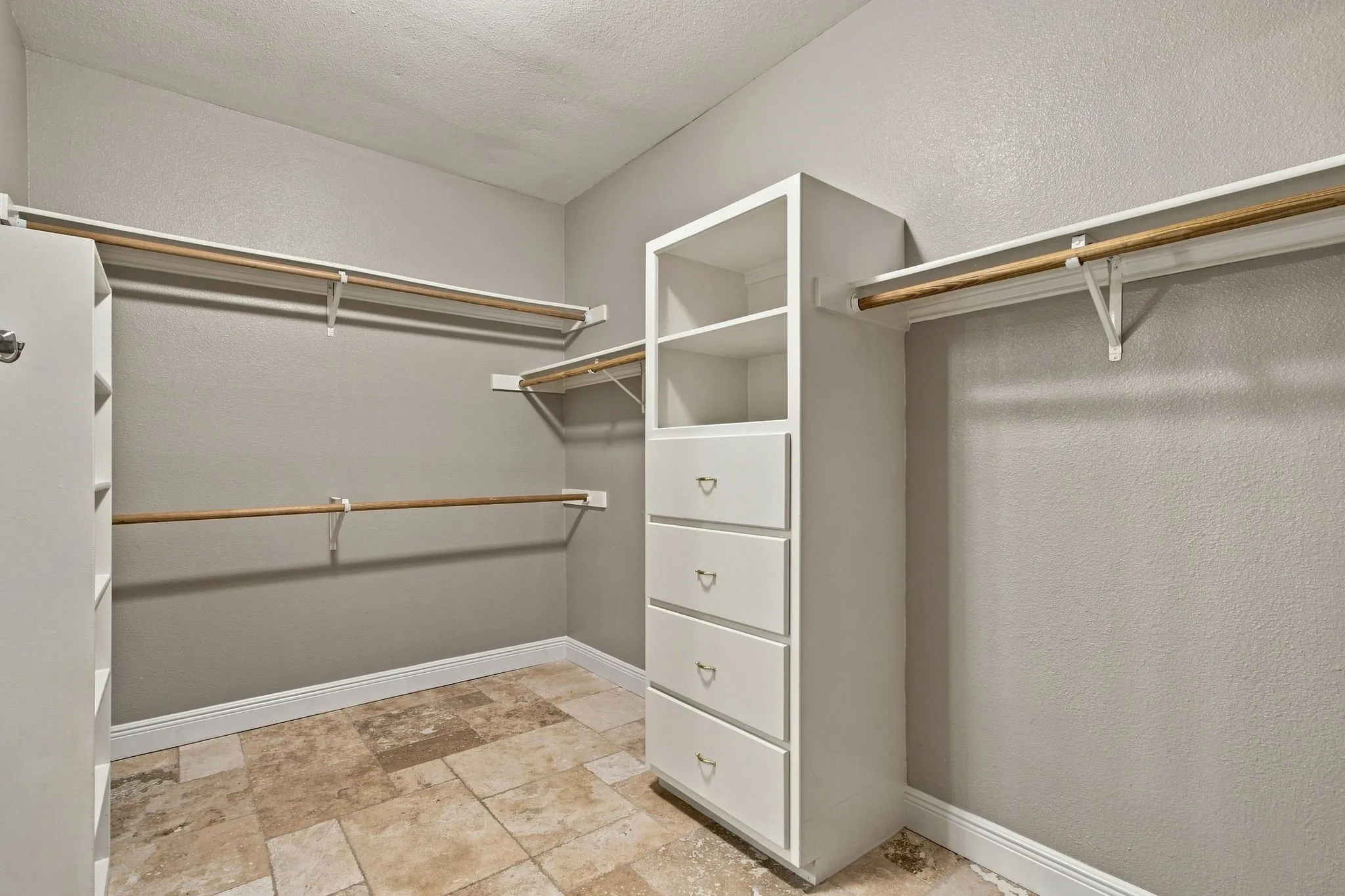 Primary Bedroom Closet with drawers and shoe shelves.