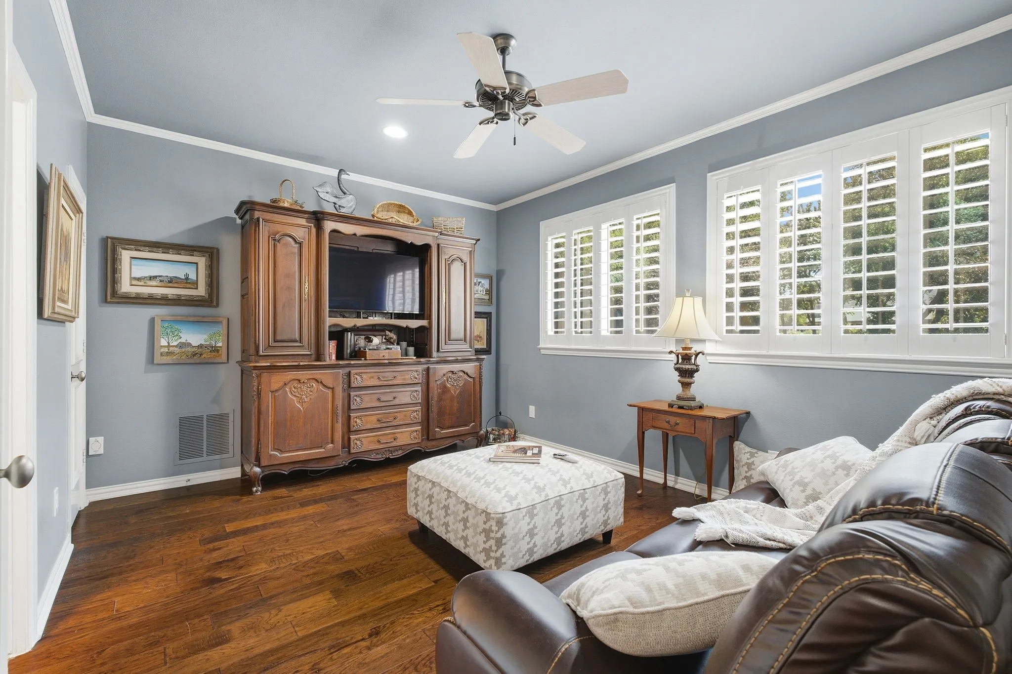 Hardwood flooring, crown molding, ceiling fan, recessed lighting, and white plantation shutters