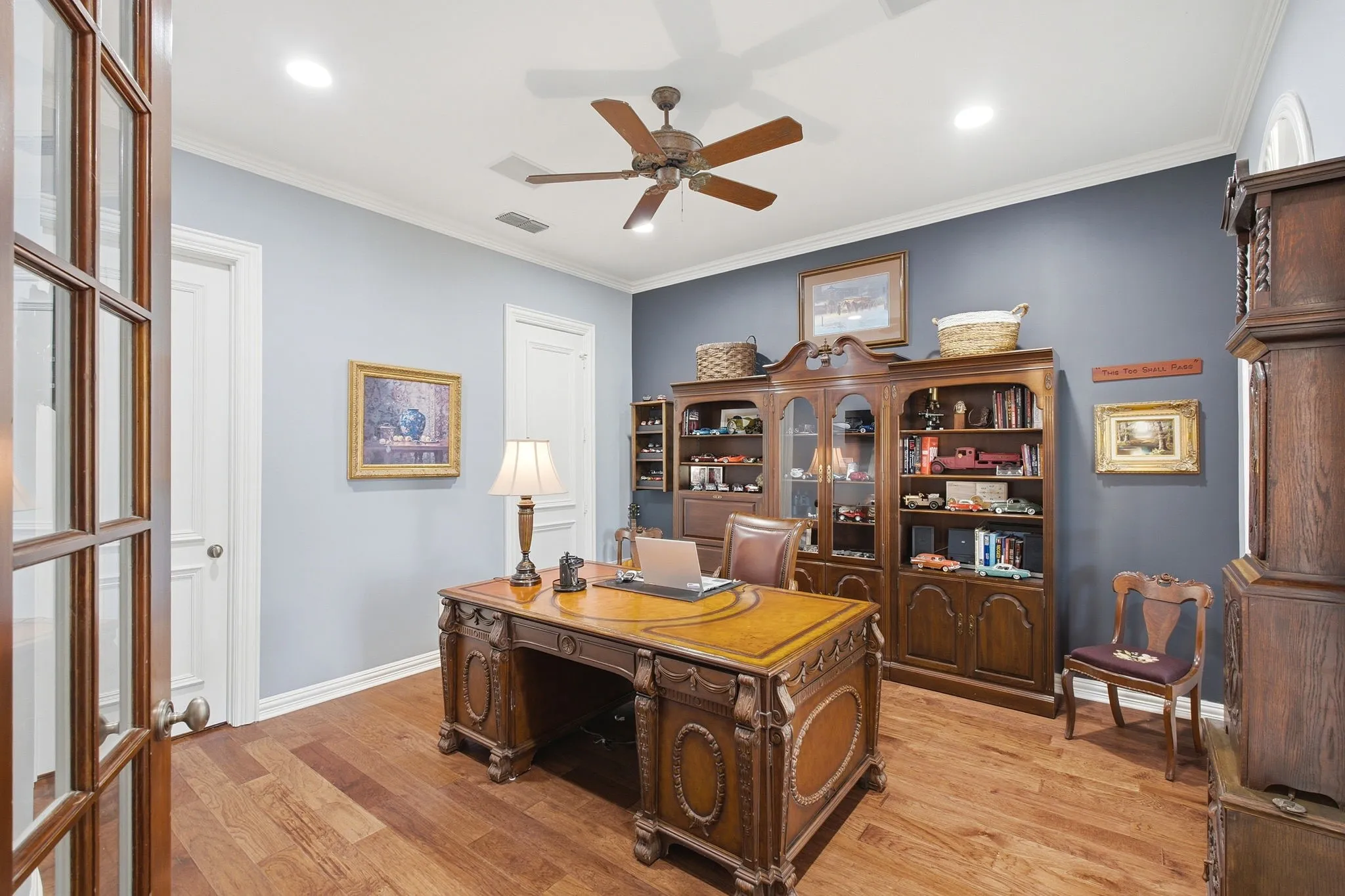 Wood-finish flooring, recessed lighting, ceiling fan, crown molding, and French doors