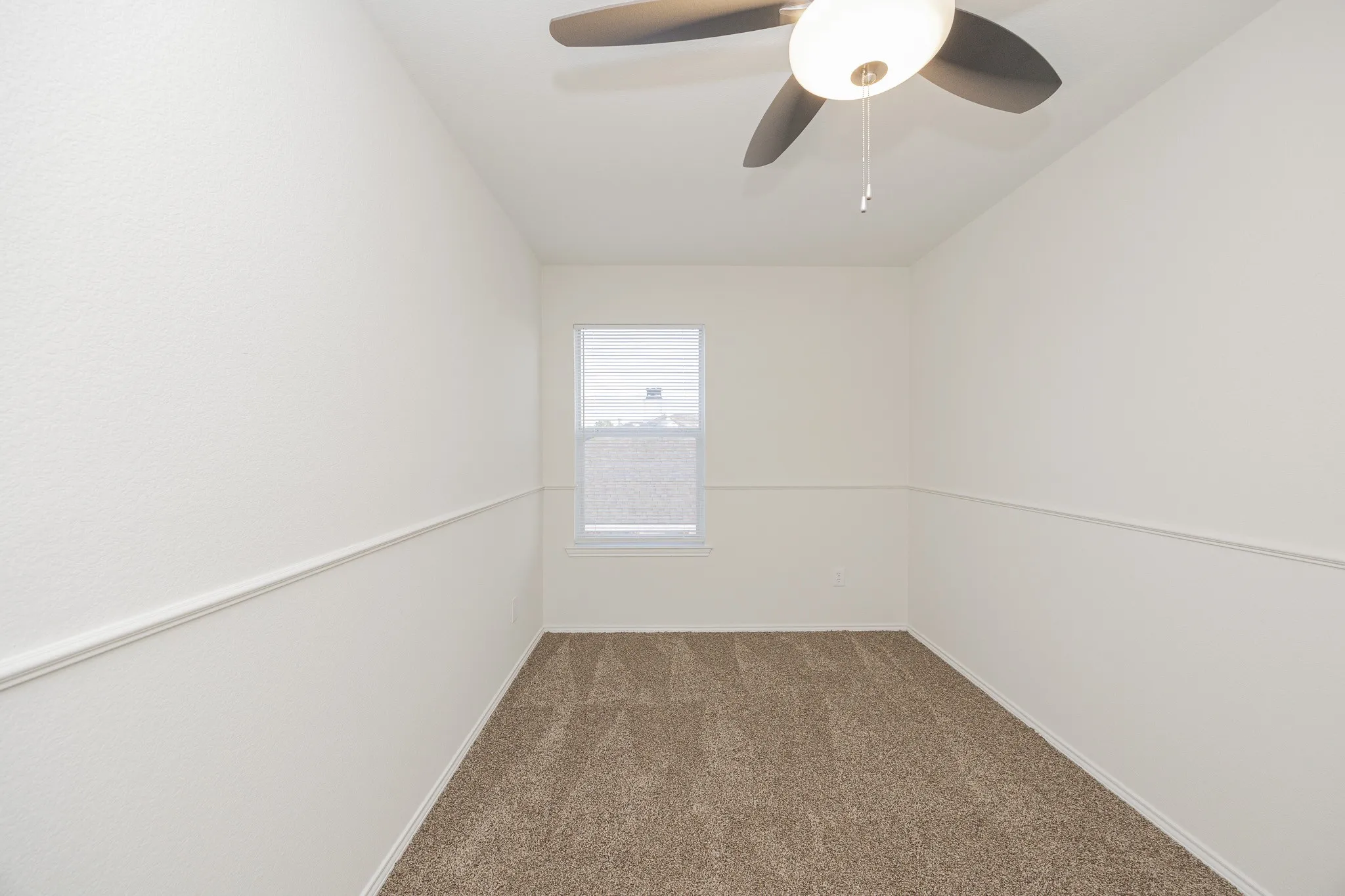 Carpeted flooring, single window, ceiling fan with light, and wall trim detail