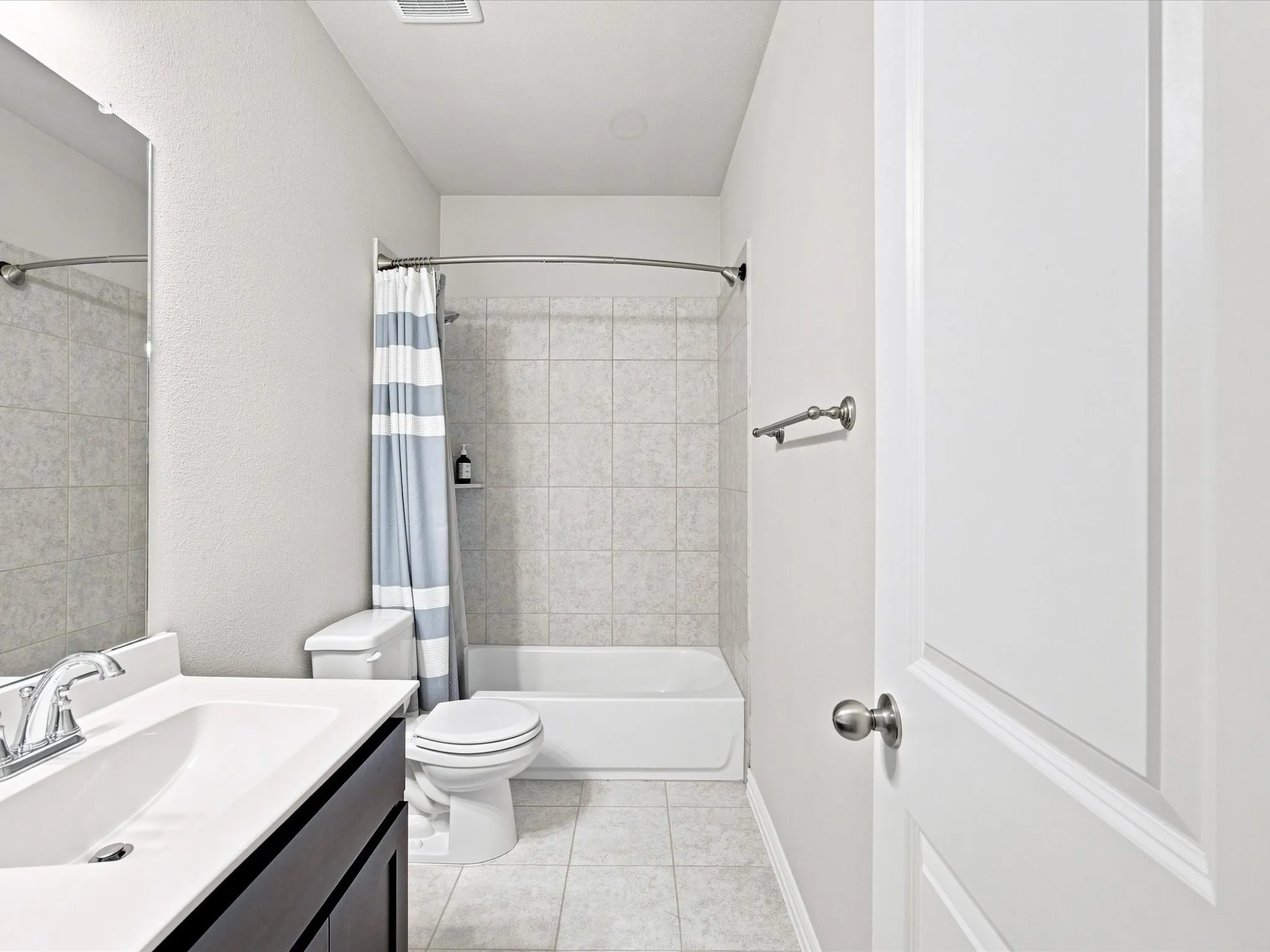 Vanity with integrated sink, chrome faucet, and dark wood-finish cabinetry