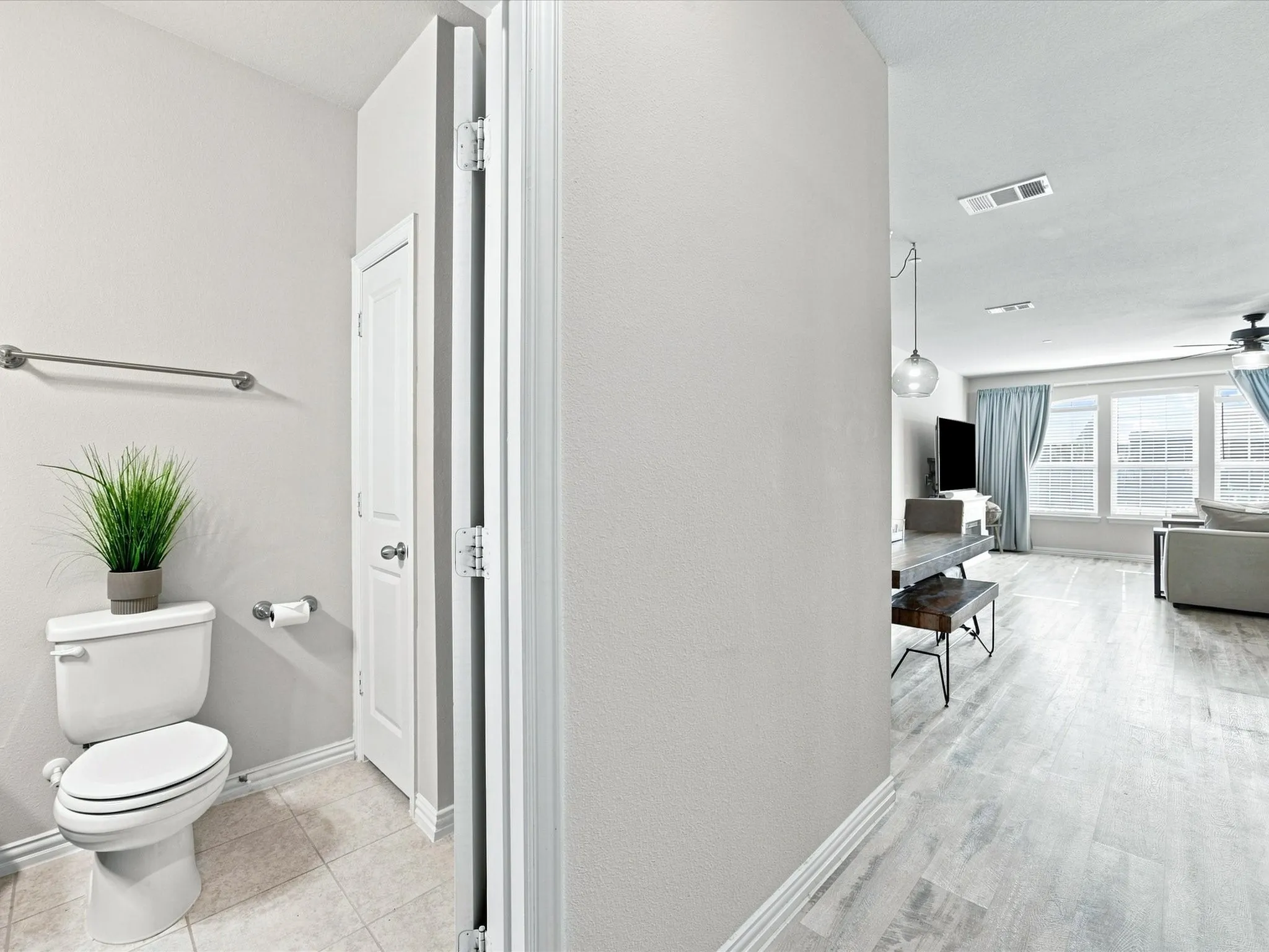 Ceramic tile flooring in the bathroom, wood-finish flooring in the main living space, and recessed lighting