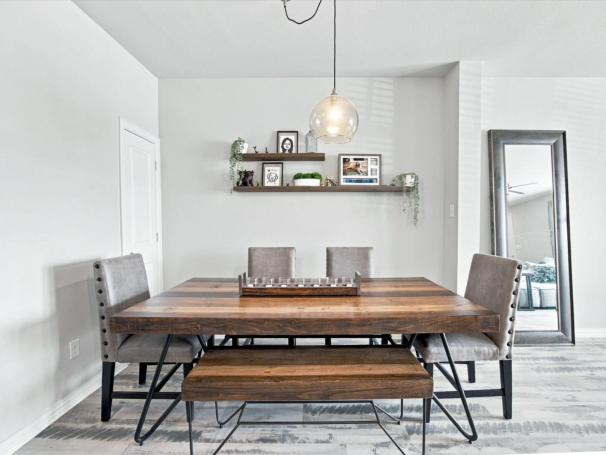 Wood-finish flooring, recessed lighting, wall-mounted shelving, and a modern light fixture