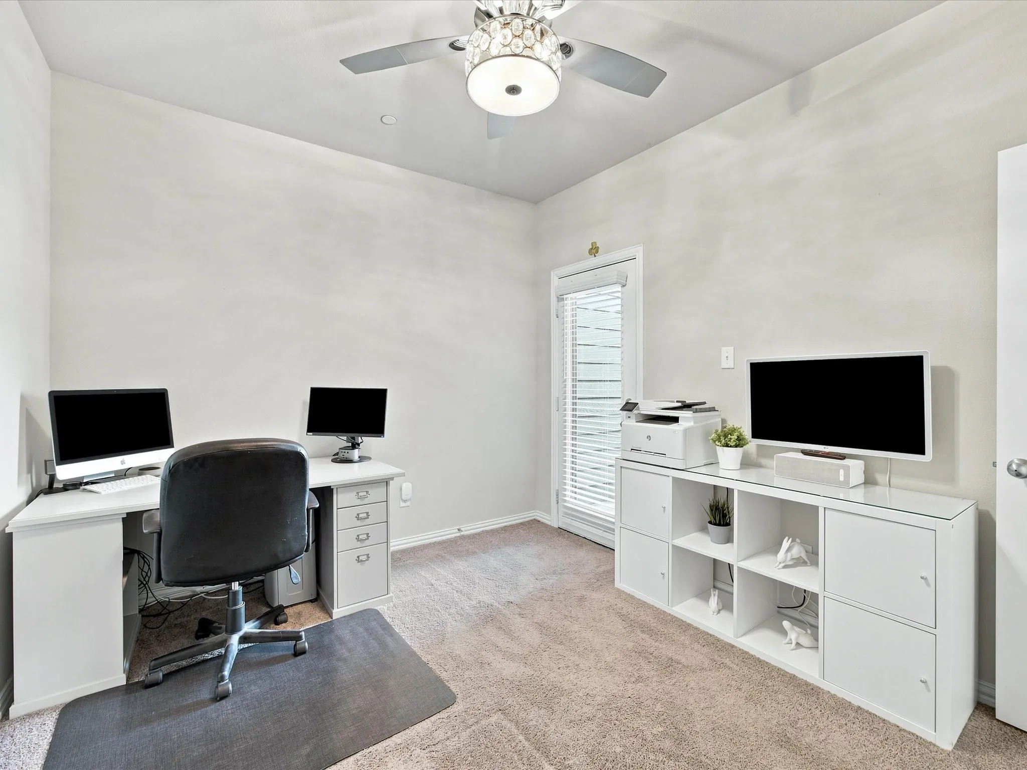 Carpeted room with a ceiling fan light fixture, white walls, and a glass-paned exterior door