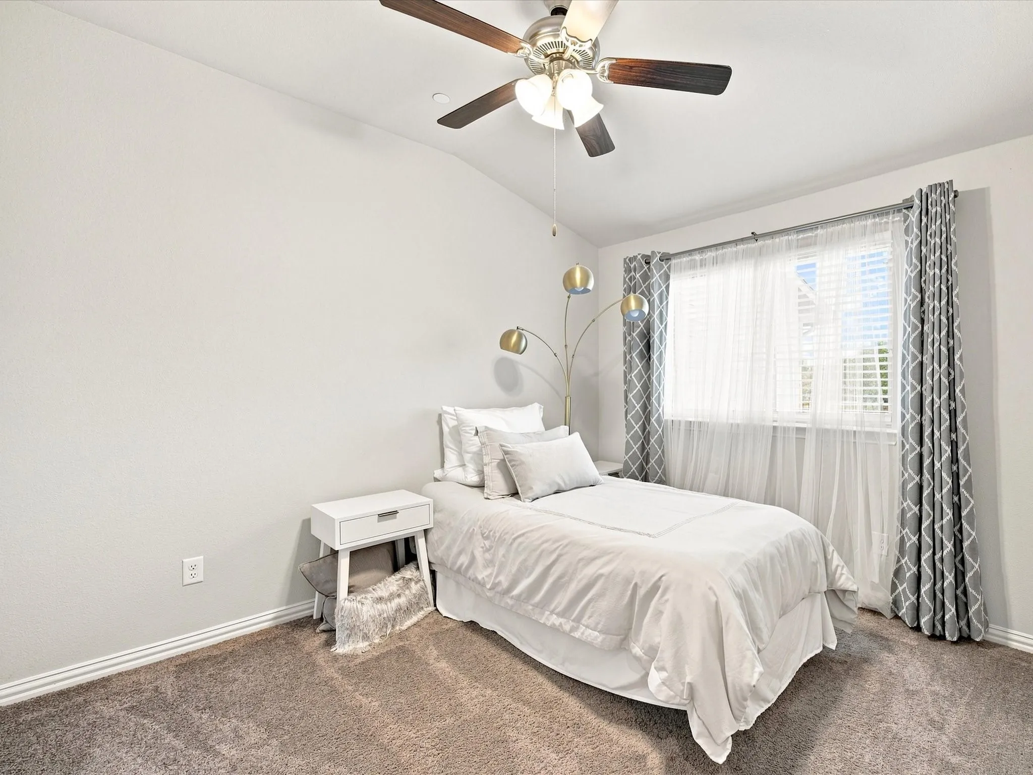 Vaulted ceiling with a ceiling fan, carpeted flooring, and a single window with blinds
