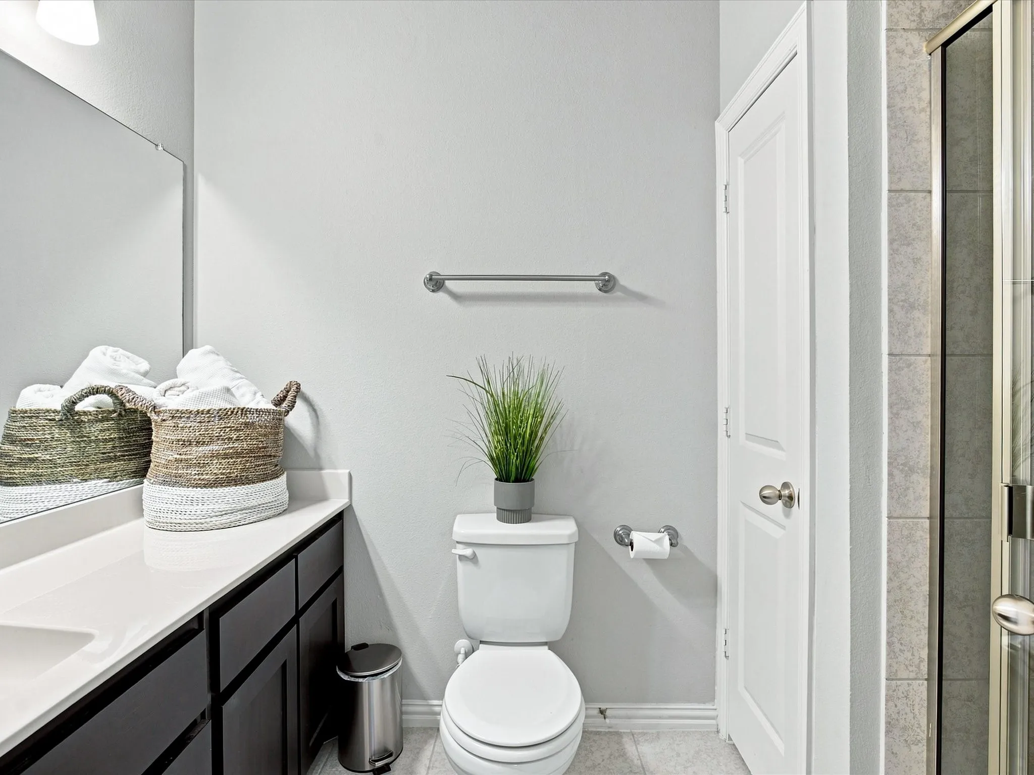 White countertop vanity with dark wood-finish cabinetry