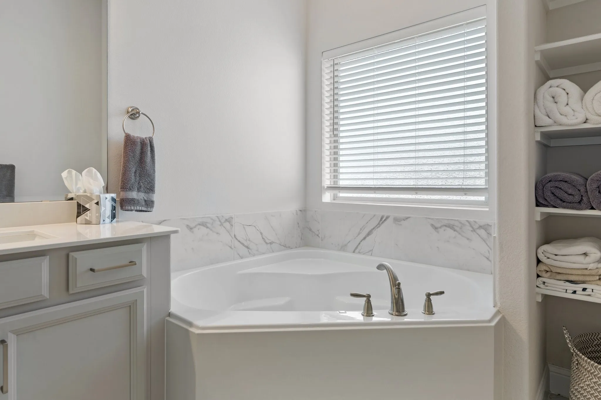 Bathroom featuring vanity, a tub to relax in, and a wealth of natural light