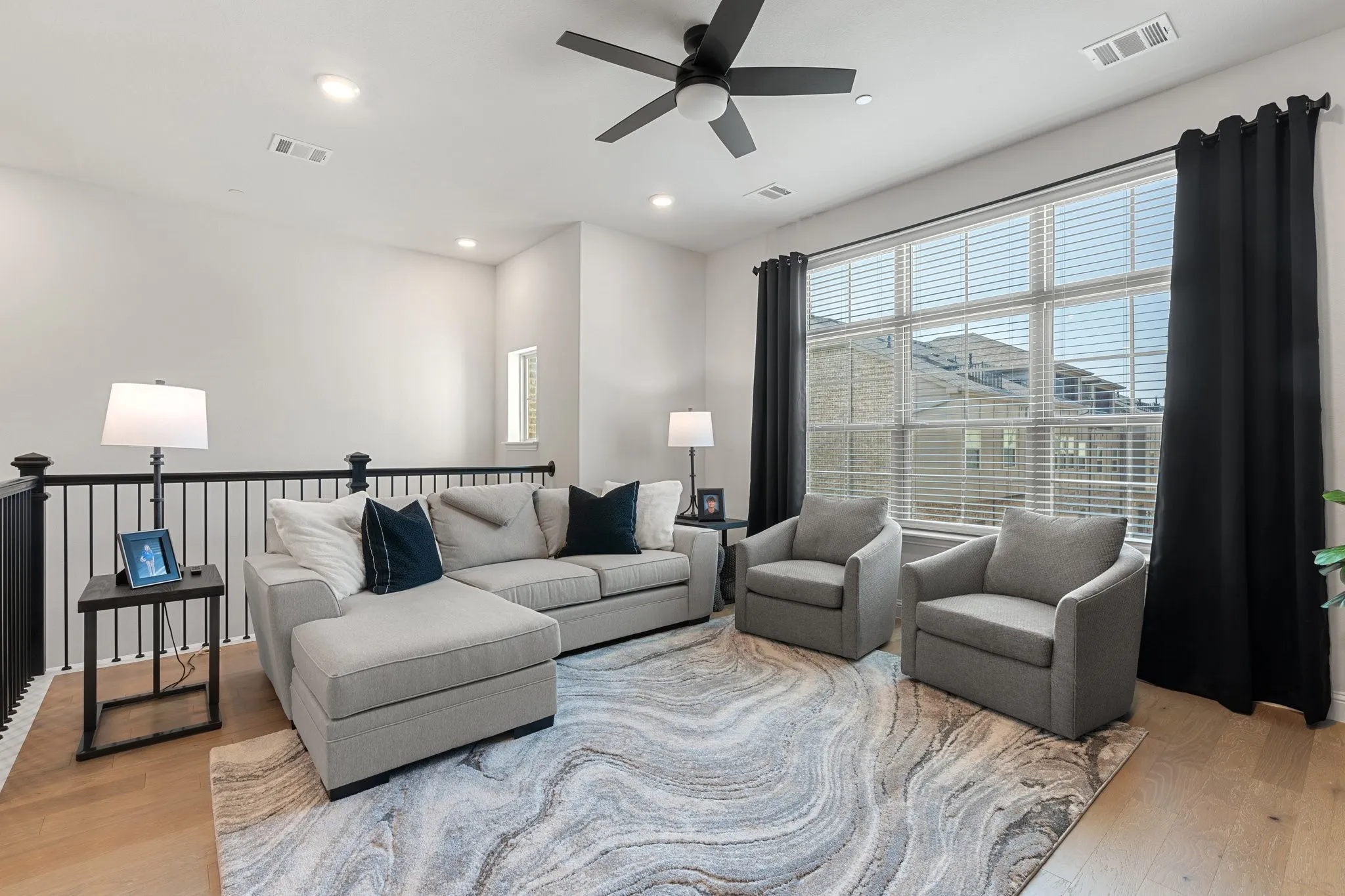 Living room with ceiling fan and hardwood / wood-style floors