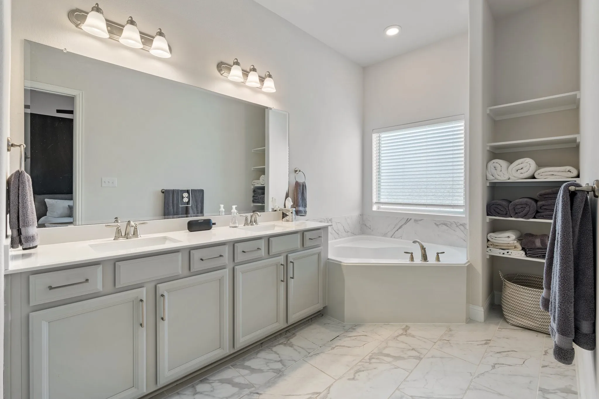Bathroom with dual vanity, tile patterned floors, and a bathing tub