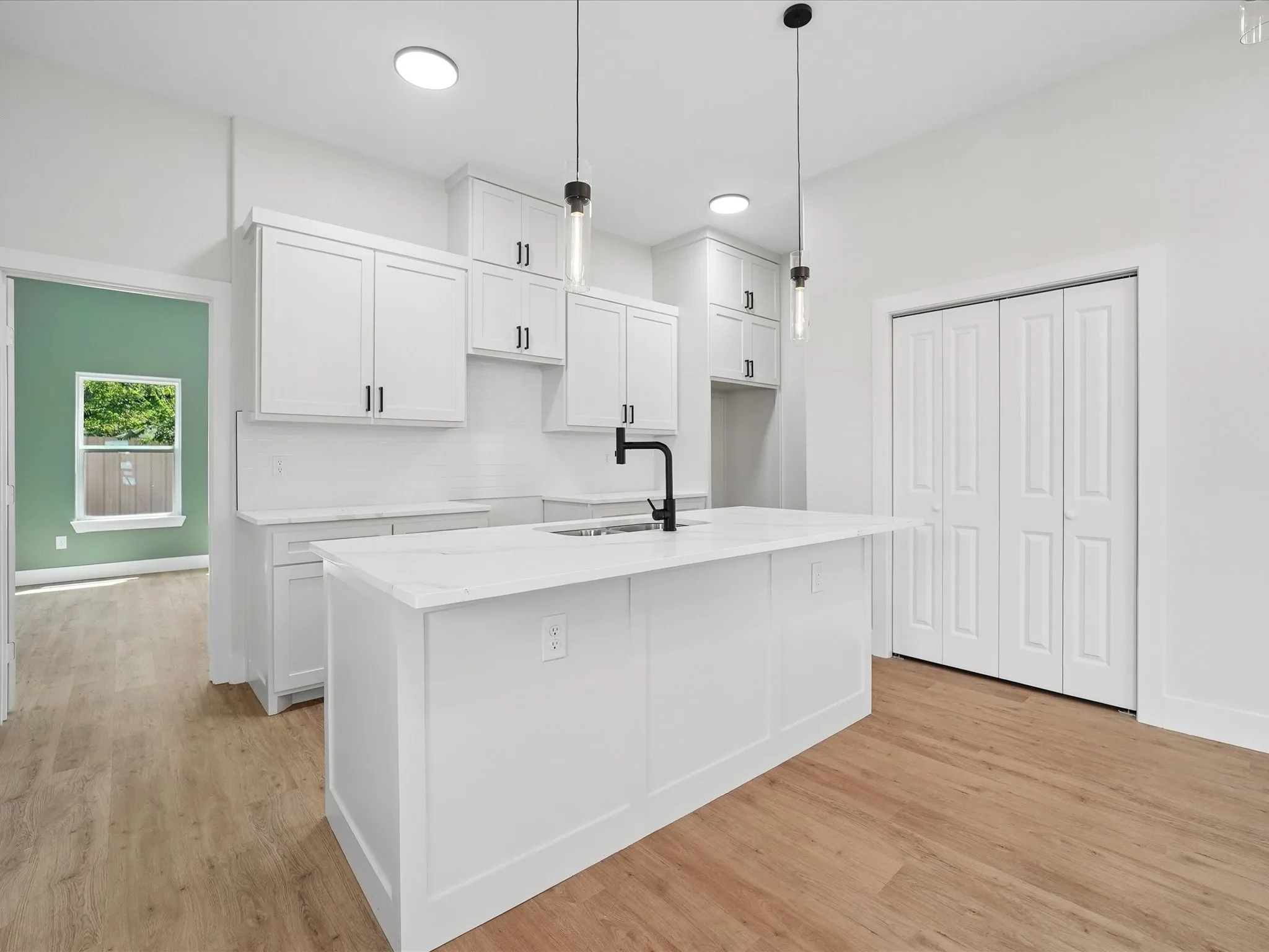 Kitchen featuring a center island, white cabinetry, white countertop surfaces, and a subway tile backsplash