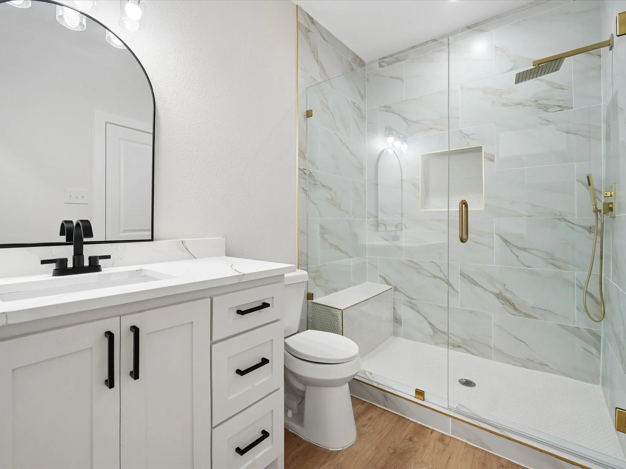 White vanity with black hardware and a white countertop