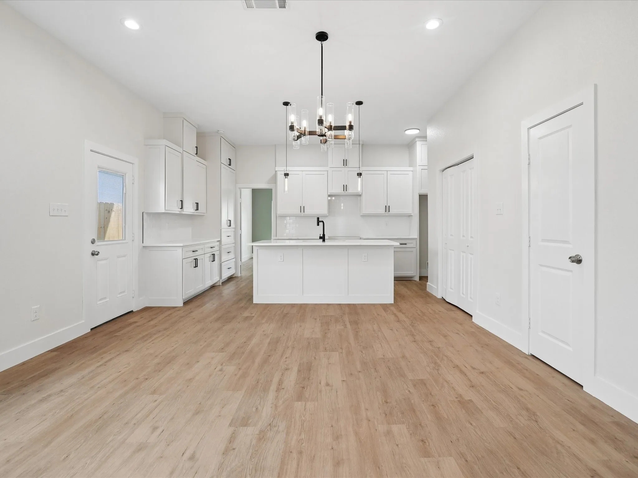 Modern kitchen with white cabinetry and a central island with an undermount sink