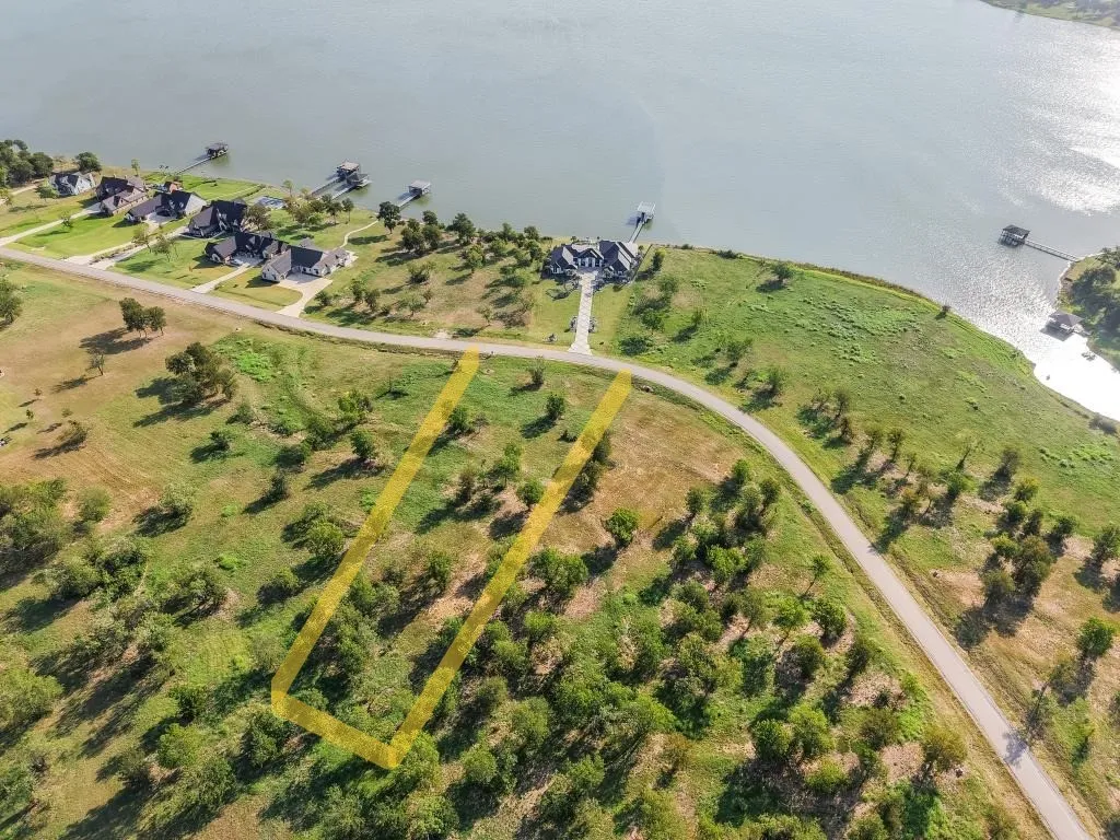 Expansive land parcel with direct road frontage, surrounded by natural vegetation, and located near a large body of water