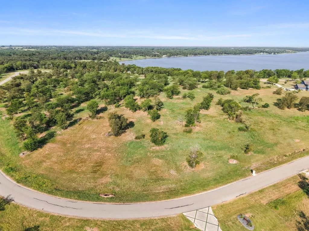 Expansive lot with mature trees, natural landscaping, and a paved road