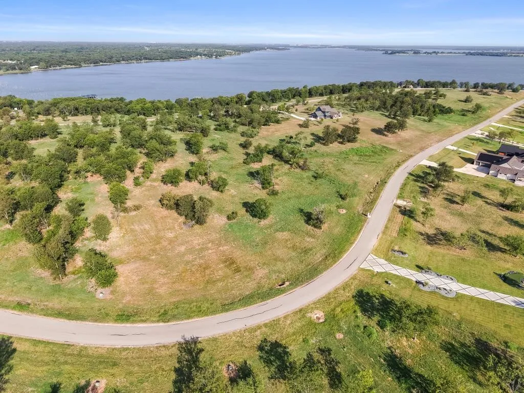 Expansive undeveloped parcel featuring mature trees, a paved roadway, and proximity to Richland Chambers