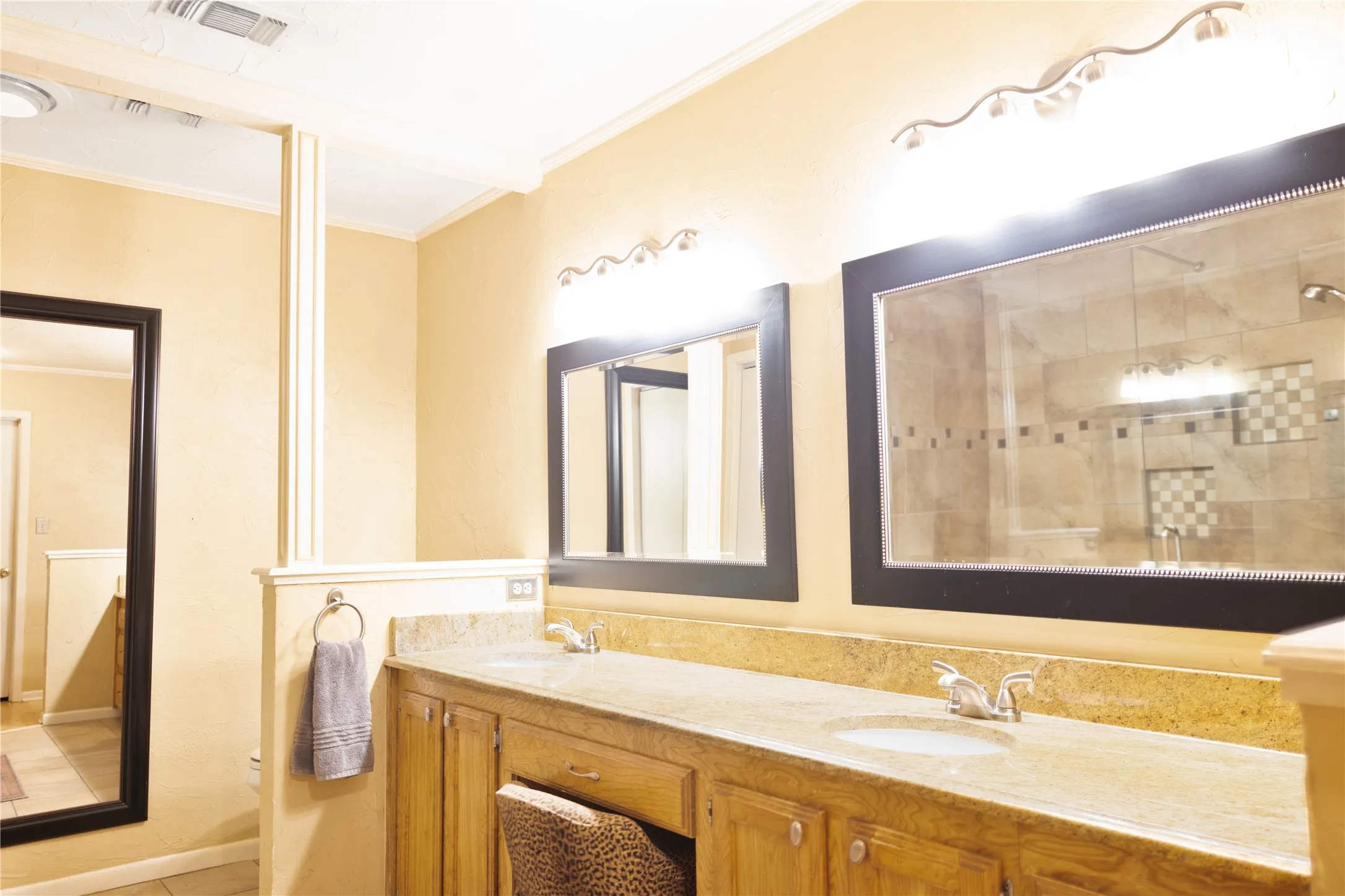 Dual vanity with integrated sinks, granite-style countertop, and wood-finish cabinetry