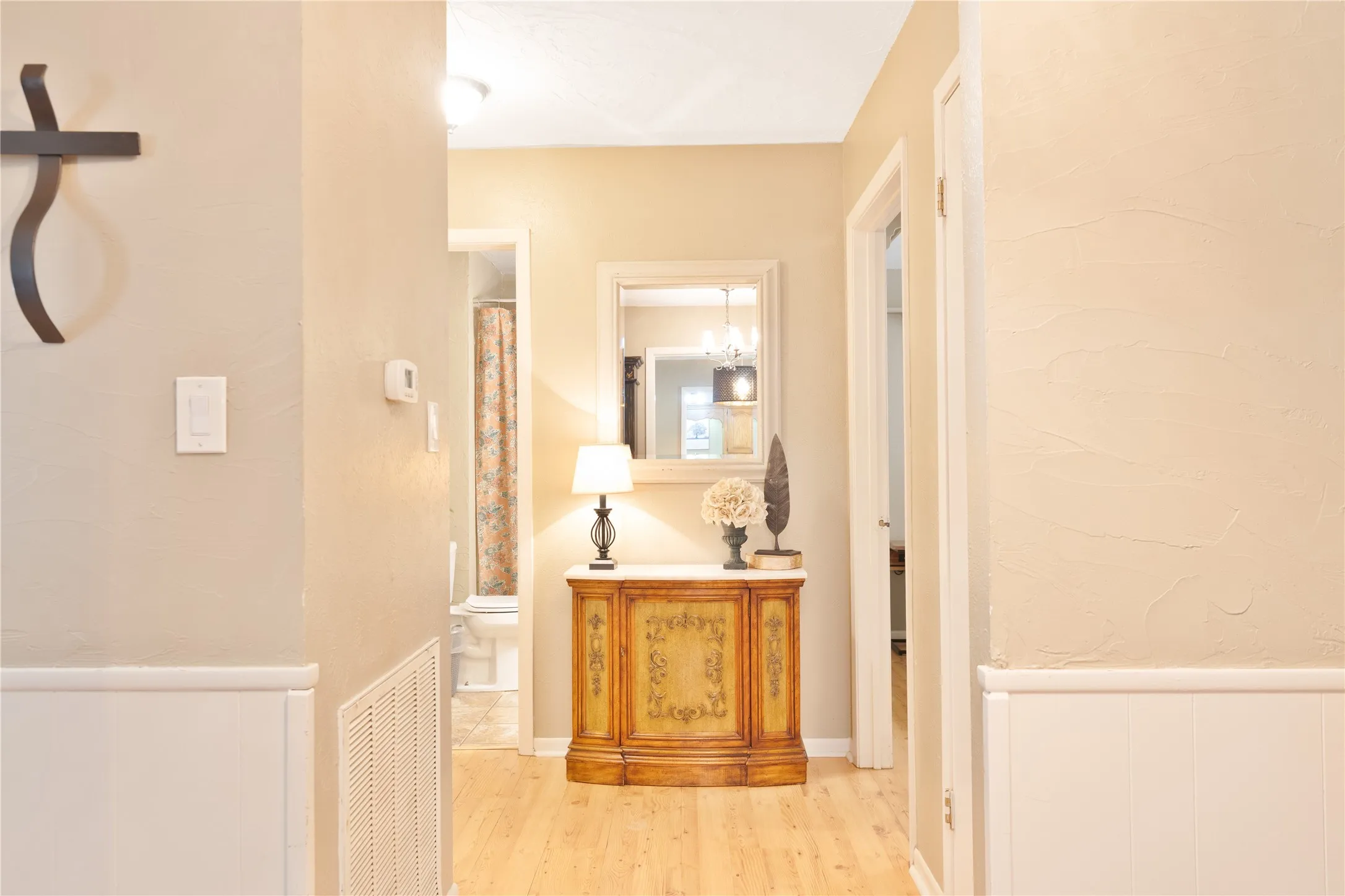 Wood-finish flooring with white wainscoting and neutral wall tones