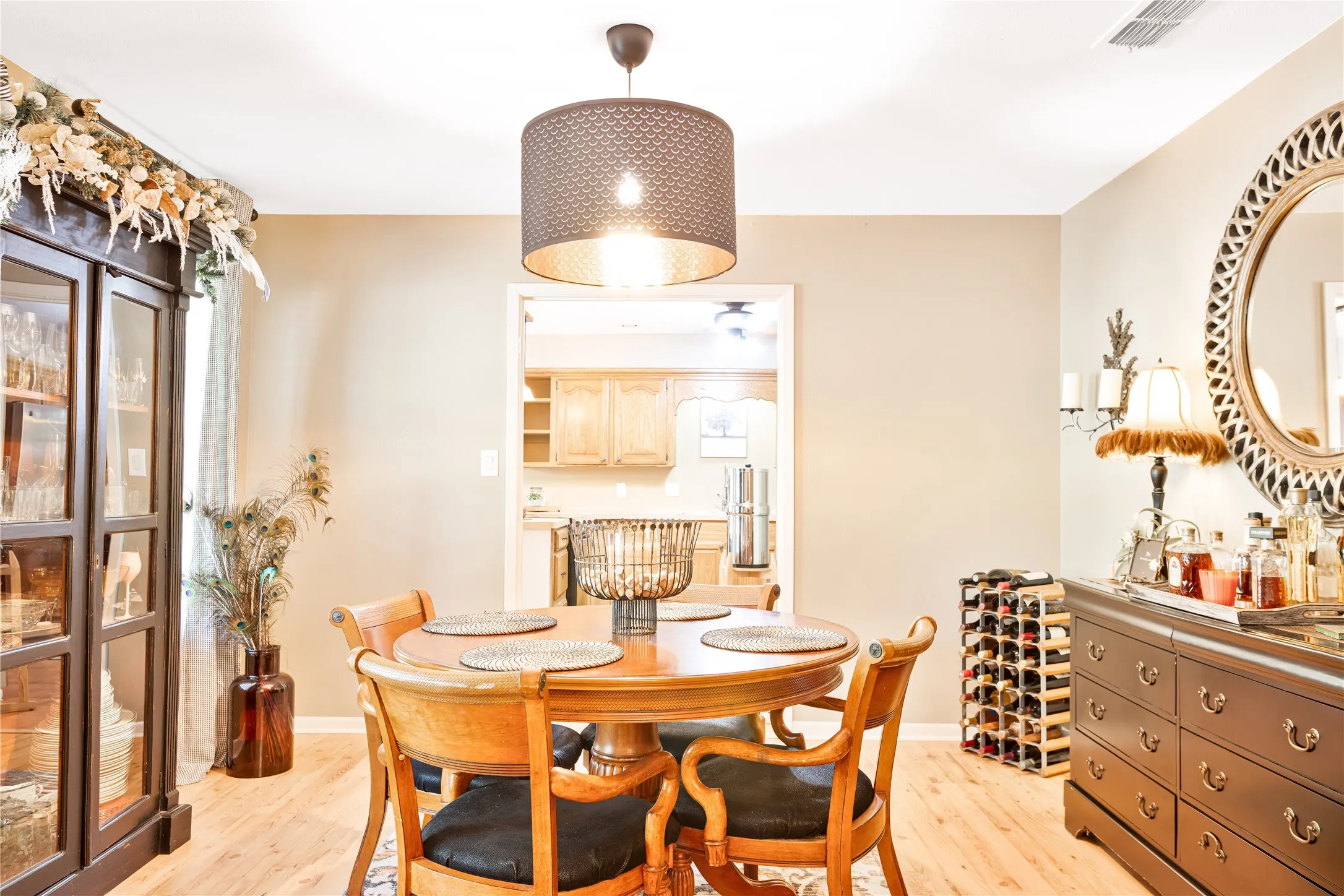 Recessed lighting, wood-finish flooring, and a decorative drum pendant light