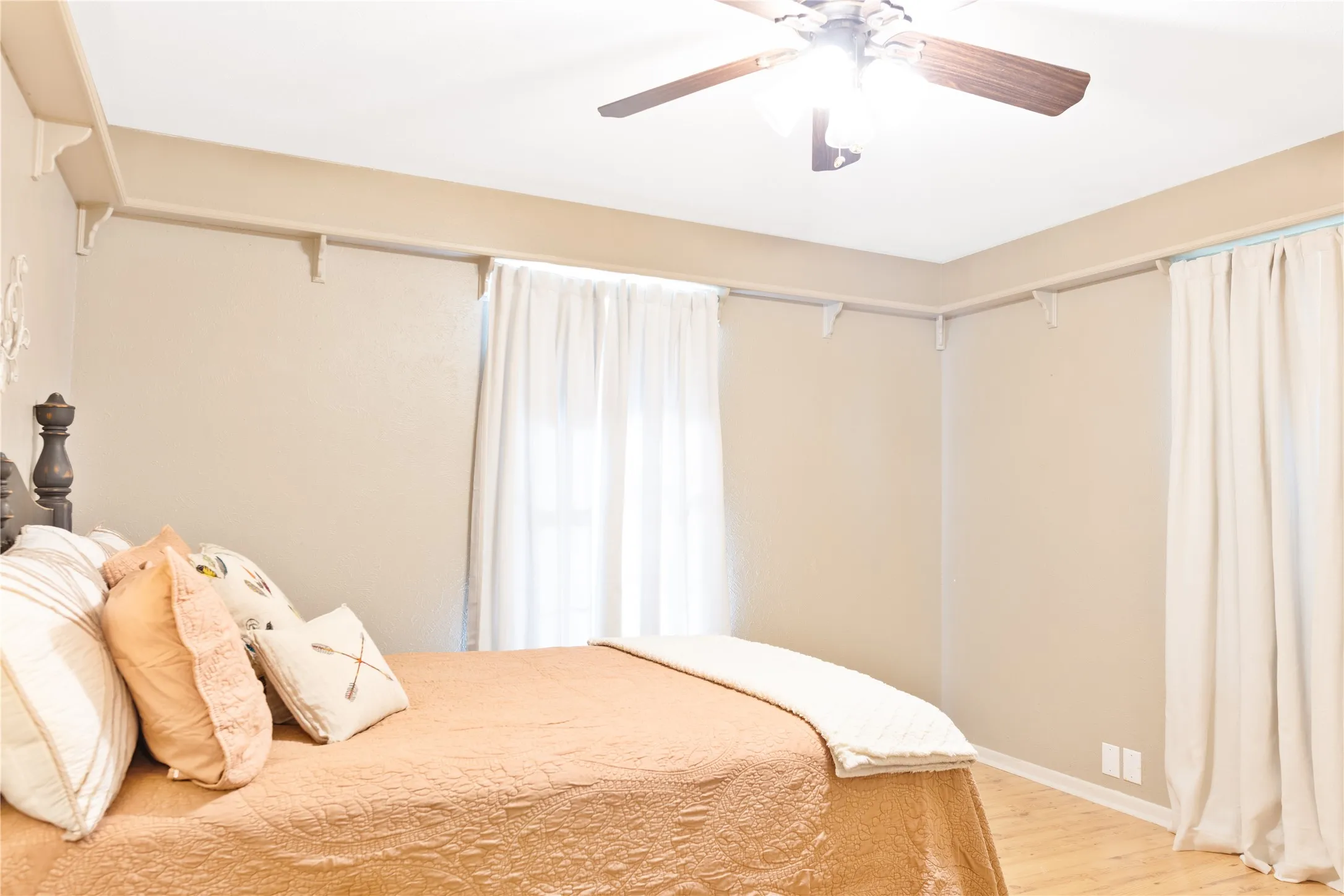 Hardwood-style flooring, ceiling fan with integrated lighting, and neutral wall tones