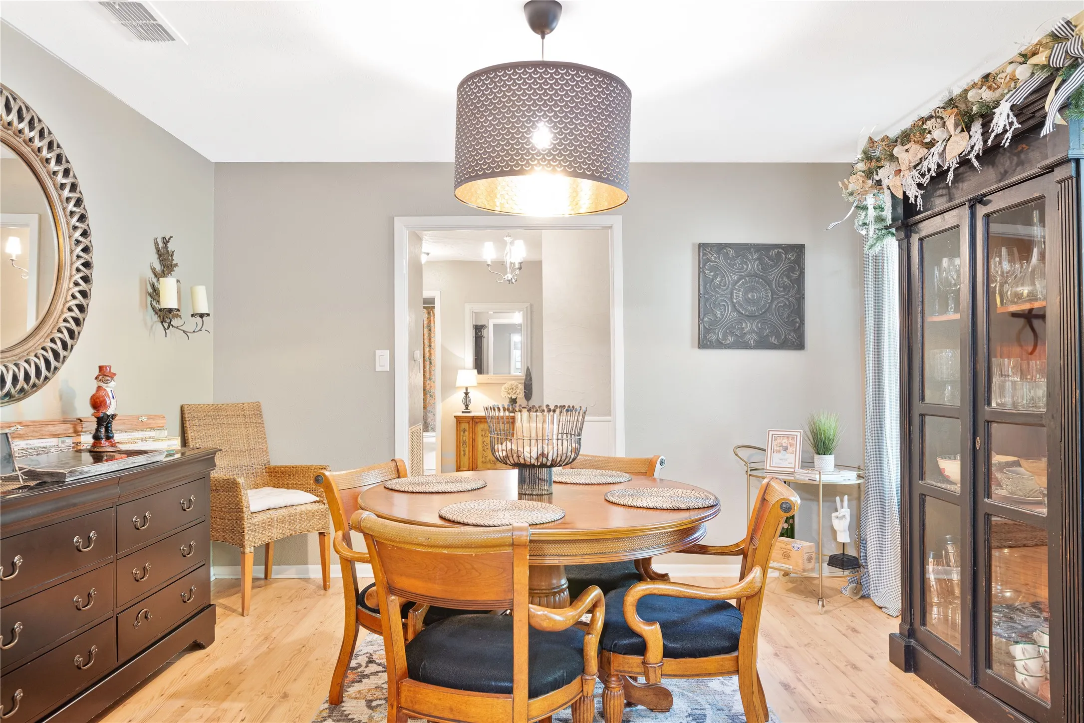 Wood-finish flooring with an area rug, and a built-in display cabinet with glass doors