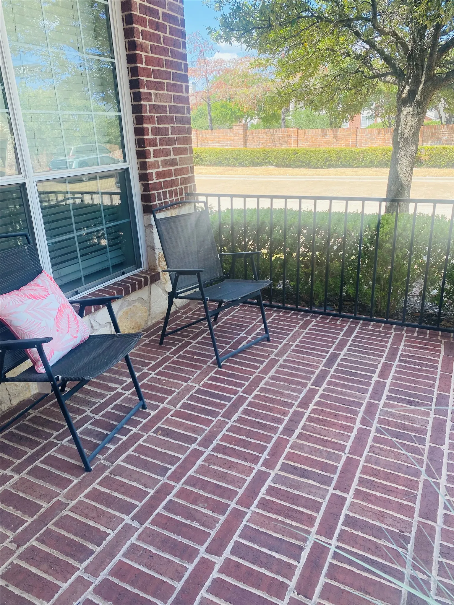 Brick front patio complemented by a black metal railing