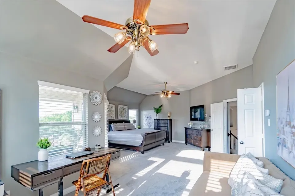 Vaulted ceilings with ceiling fans, multiple windows with blinds, and light gray wall finishes