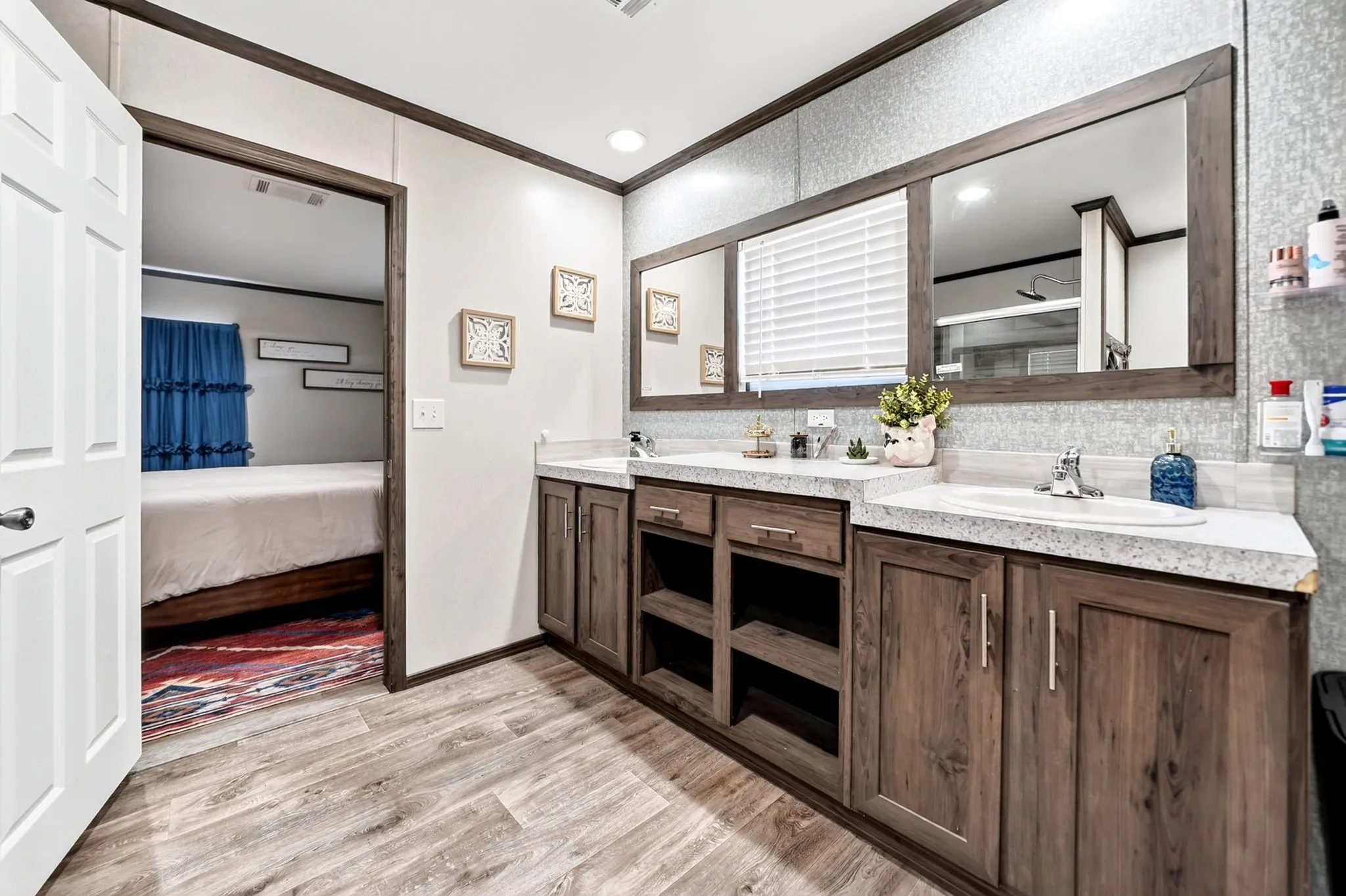 Dual vanity with integrated sinks, wood-finish cabinetry, and framed mirrors