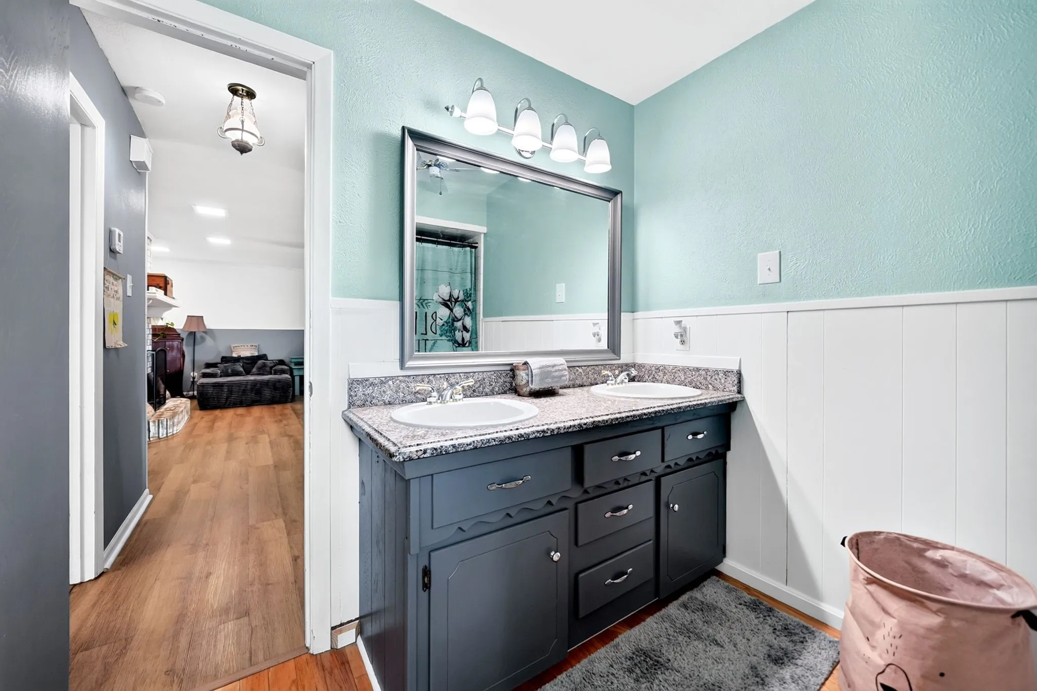 Dual vanity with drop-in sinks, granite-style countertop, and a framed mirror