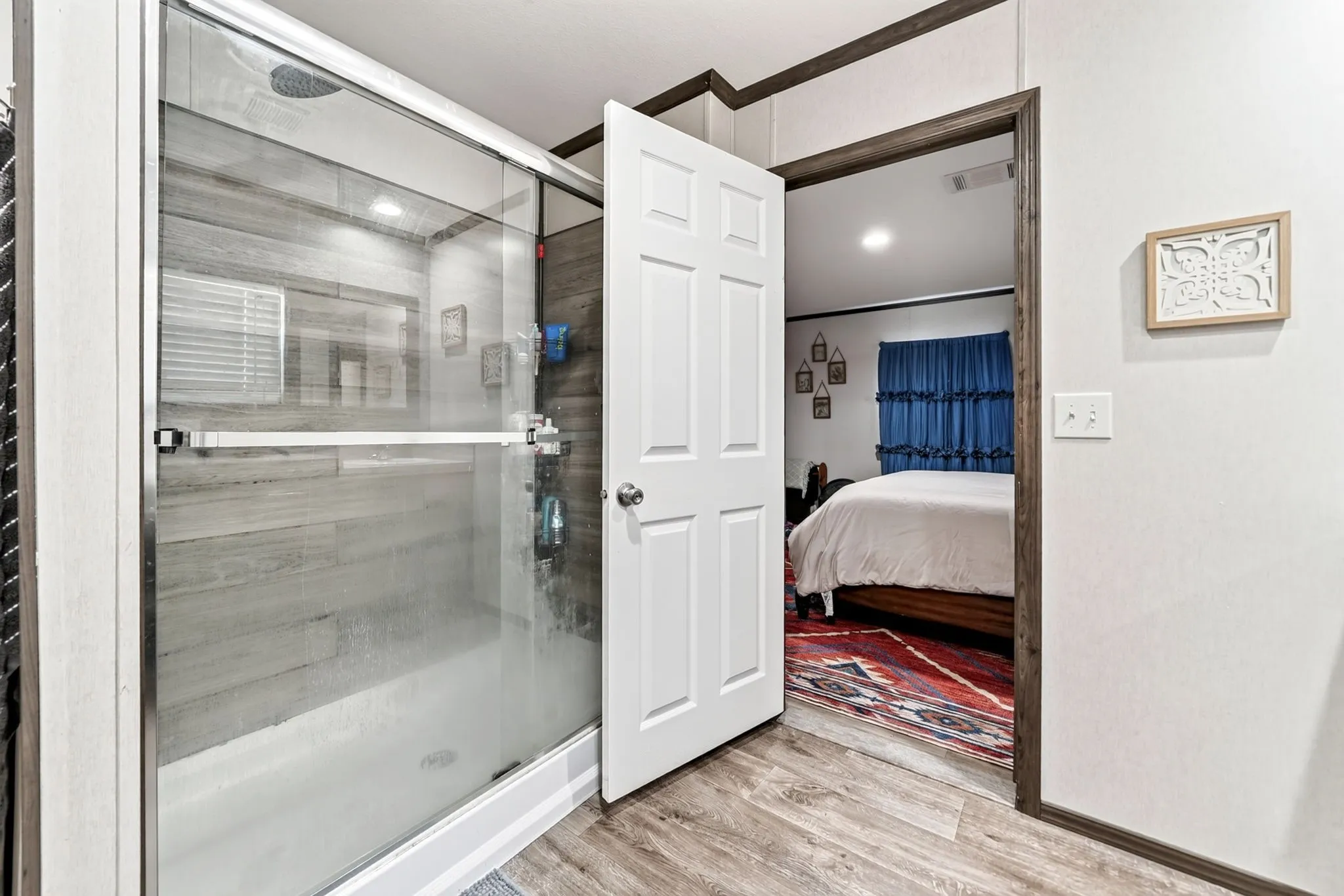 Glass-enclosed shower with wood-finish wall panels