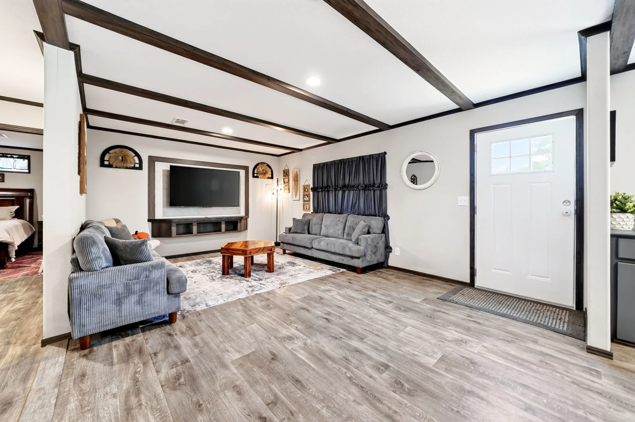 Wood-finish flooring throughout, with exposed dark wood ceiling beams and recessed lighting