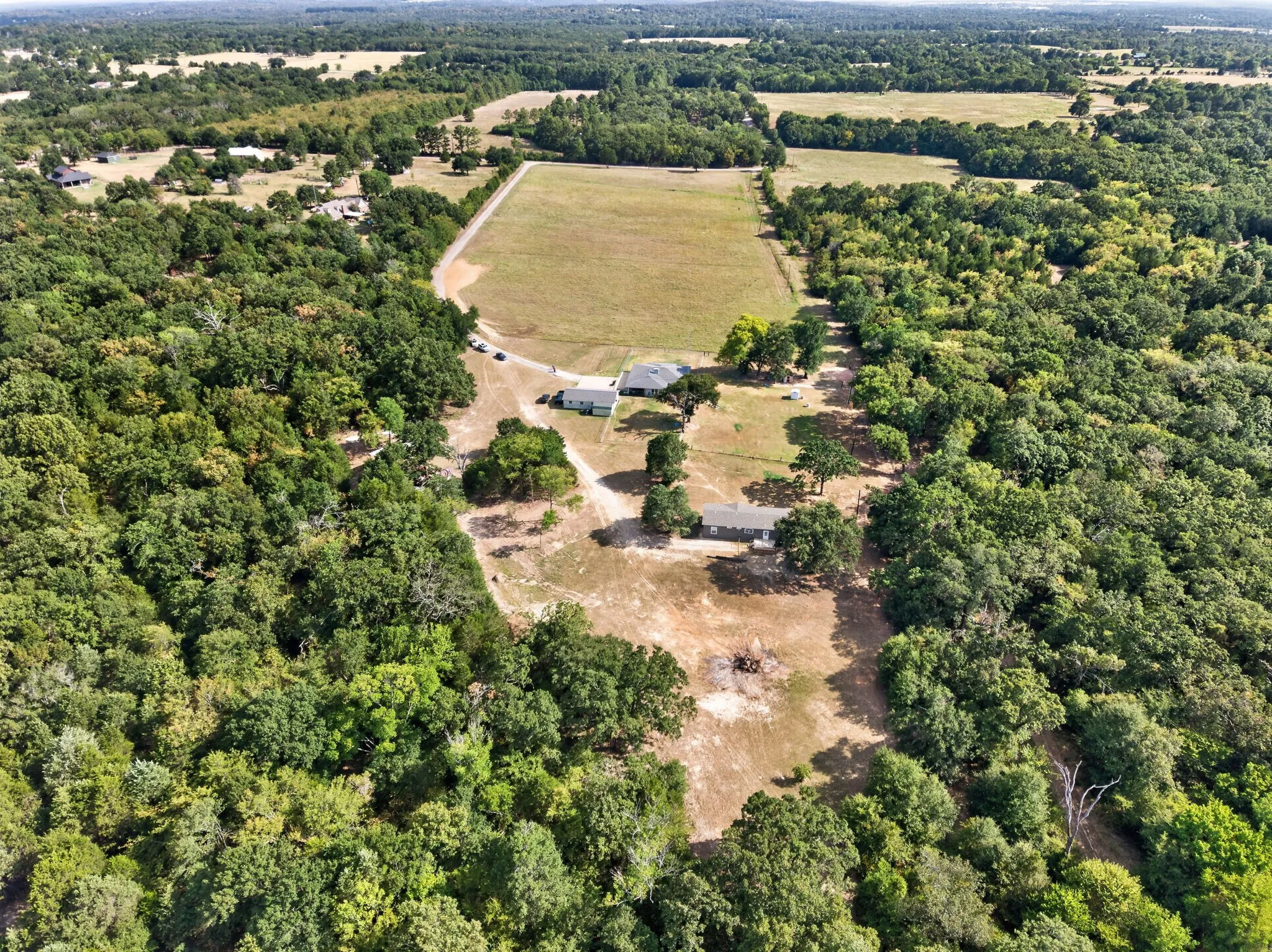 Expansive property featuring mature trees, open clearings, and a developed road system