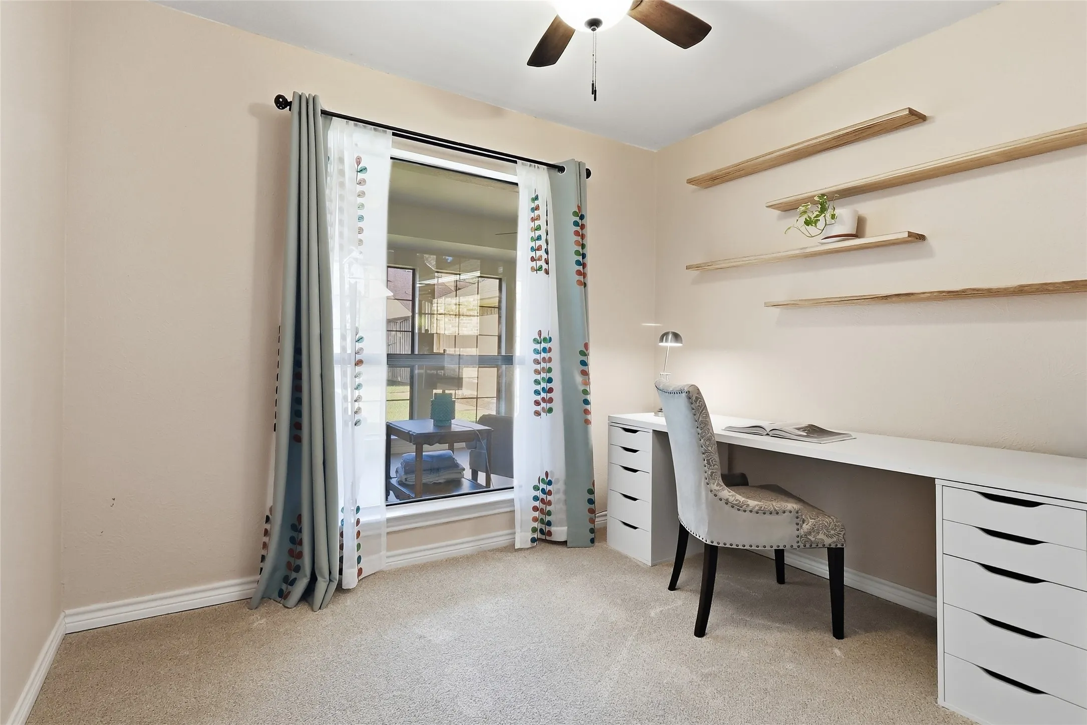 Recessed window with exterior visibility, wood-finish ceiling fan, and built-in floating shelves