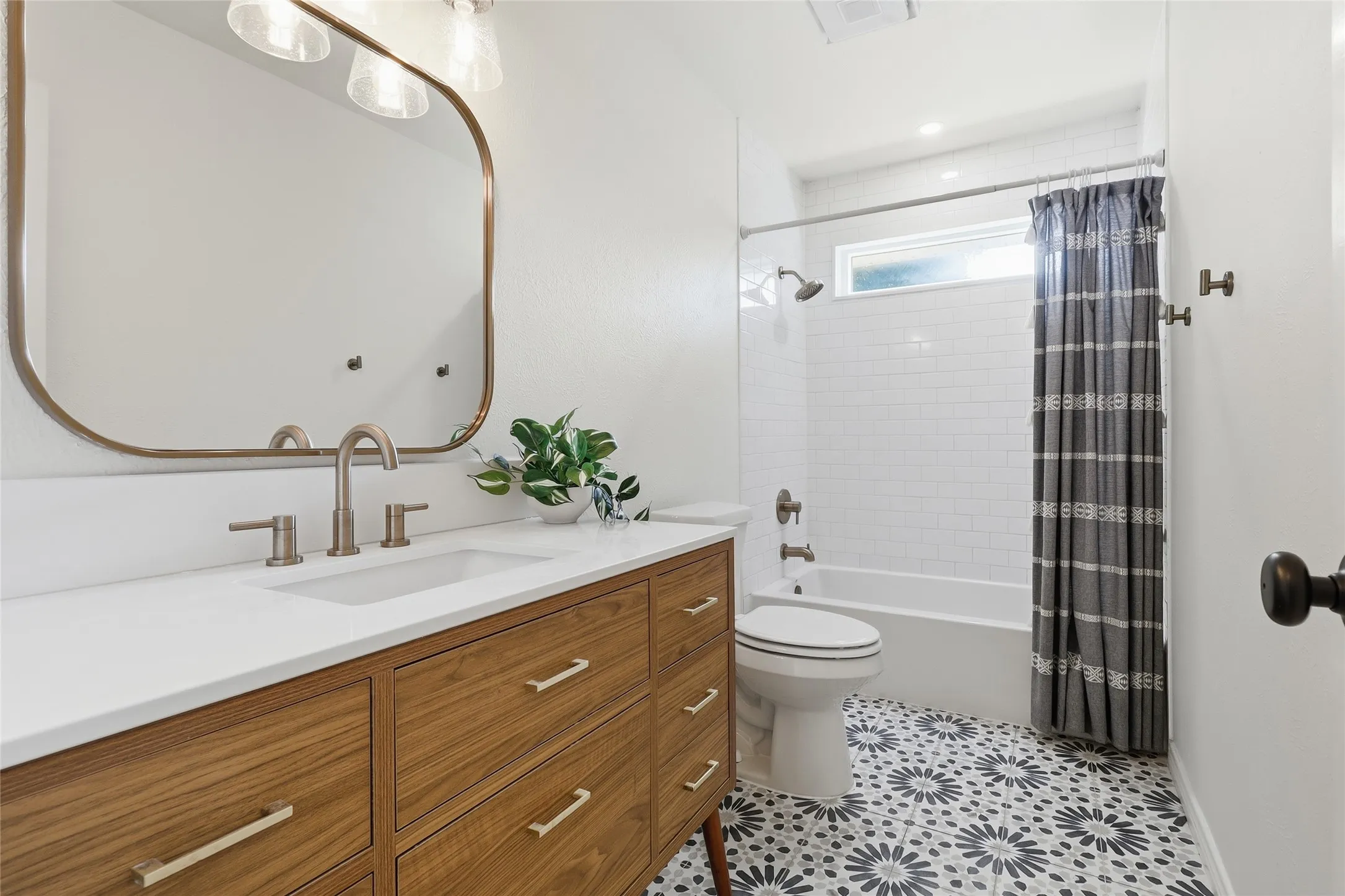 Wood-finish vanity with a white countertop and undermount sink