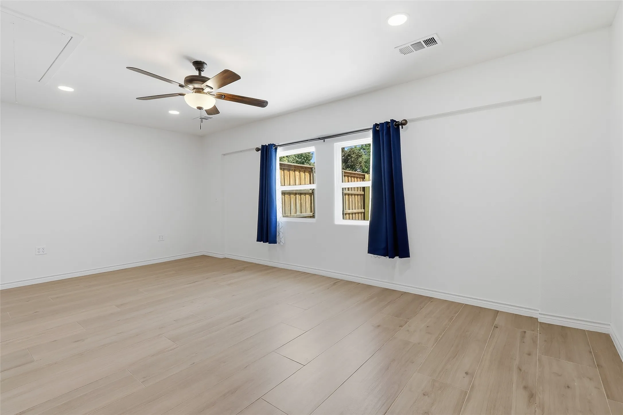 Recessed lighting, wood-finish flooring, and a ceiling fan with integrated light
