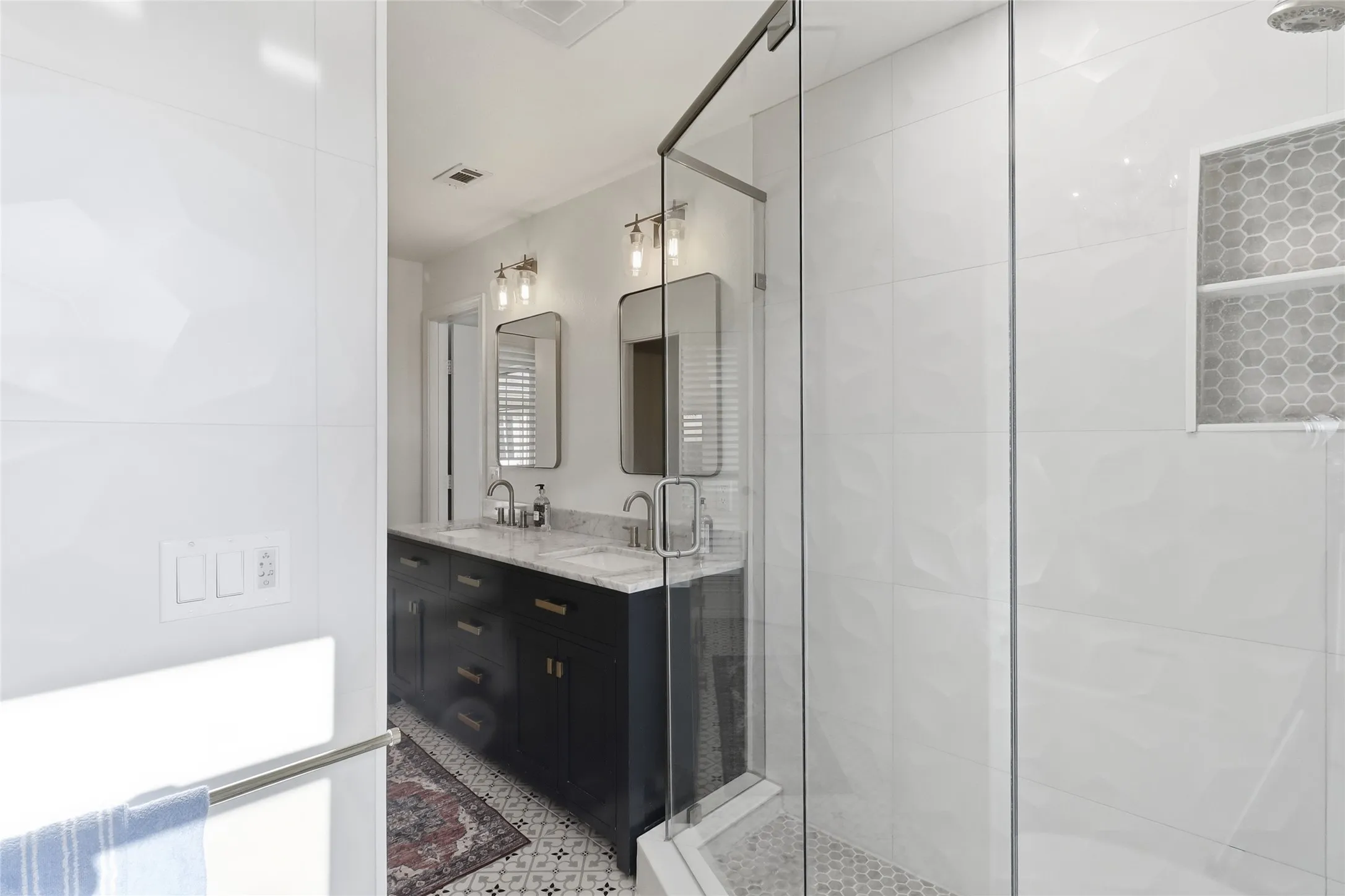 Master bathroom with glass enclosed shower with honeycomb tile niche